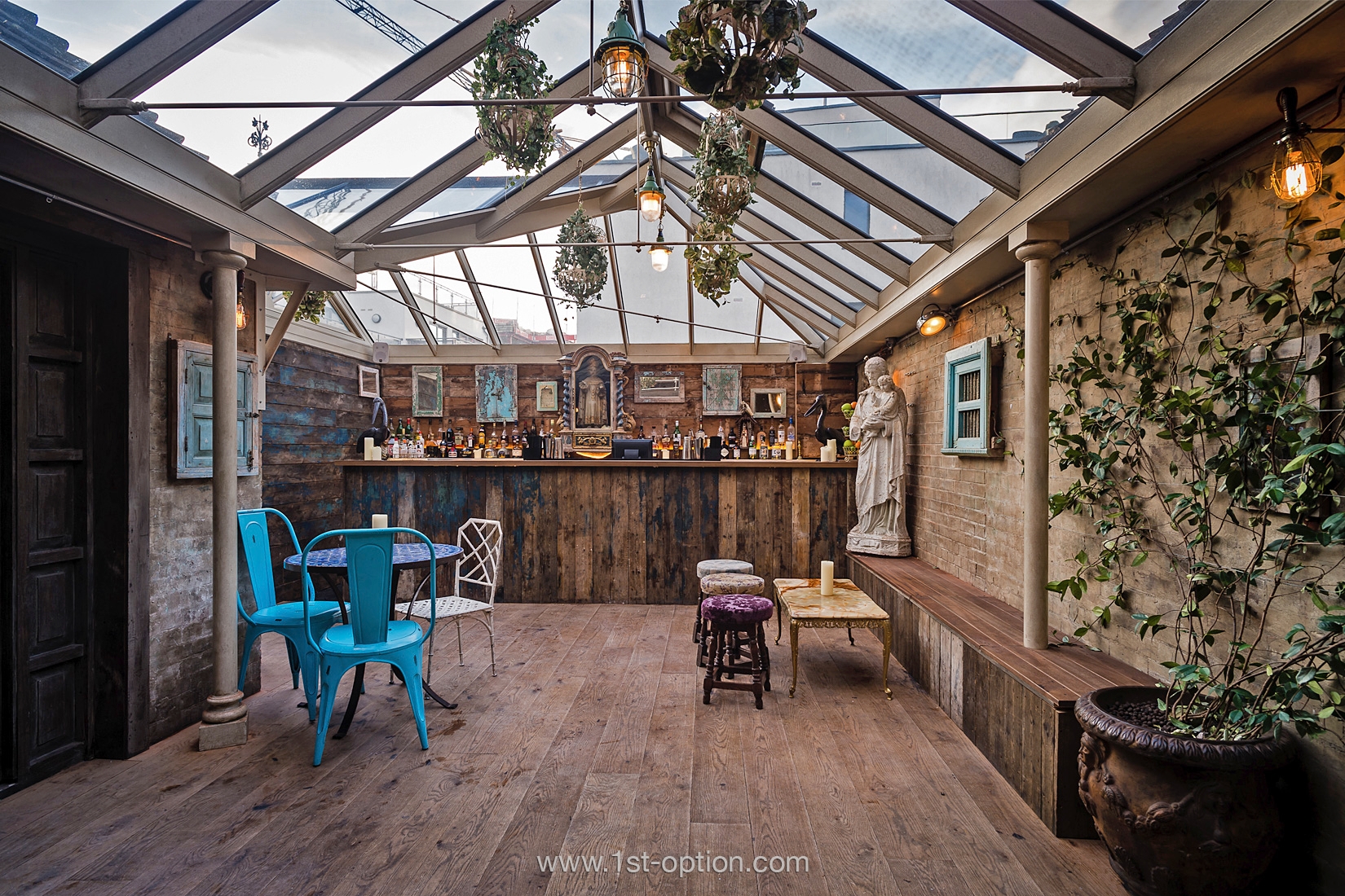Rustic event space with glass roof, ideal for intimate gatherings and creative meetings.