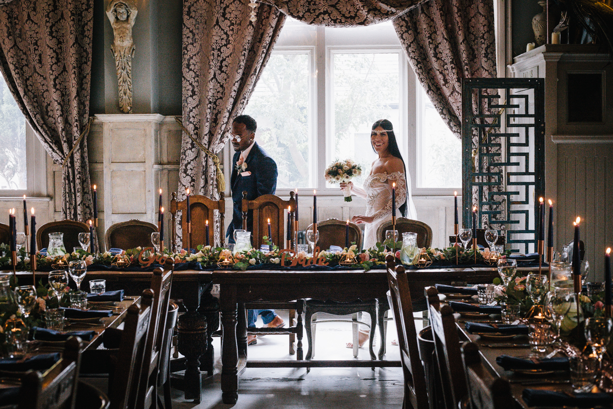 Elegant wedding reception dining room with floral arrangements and candles.