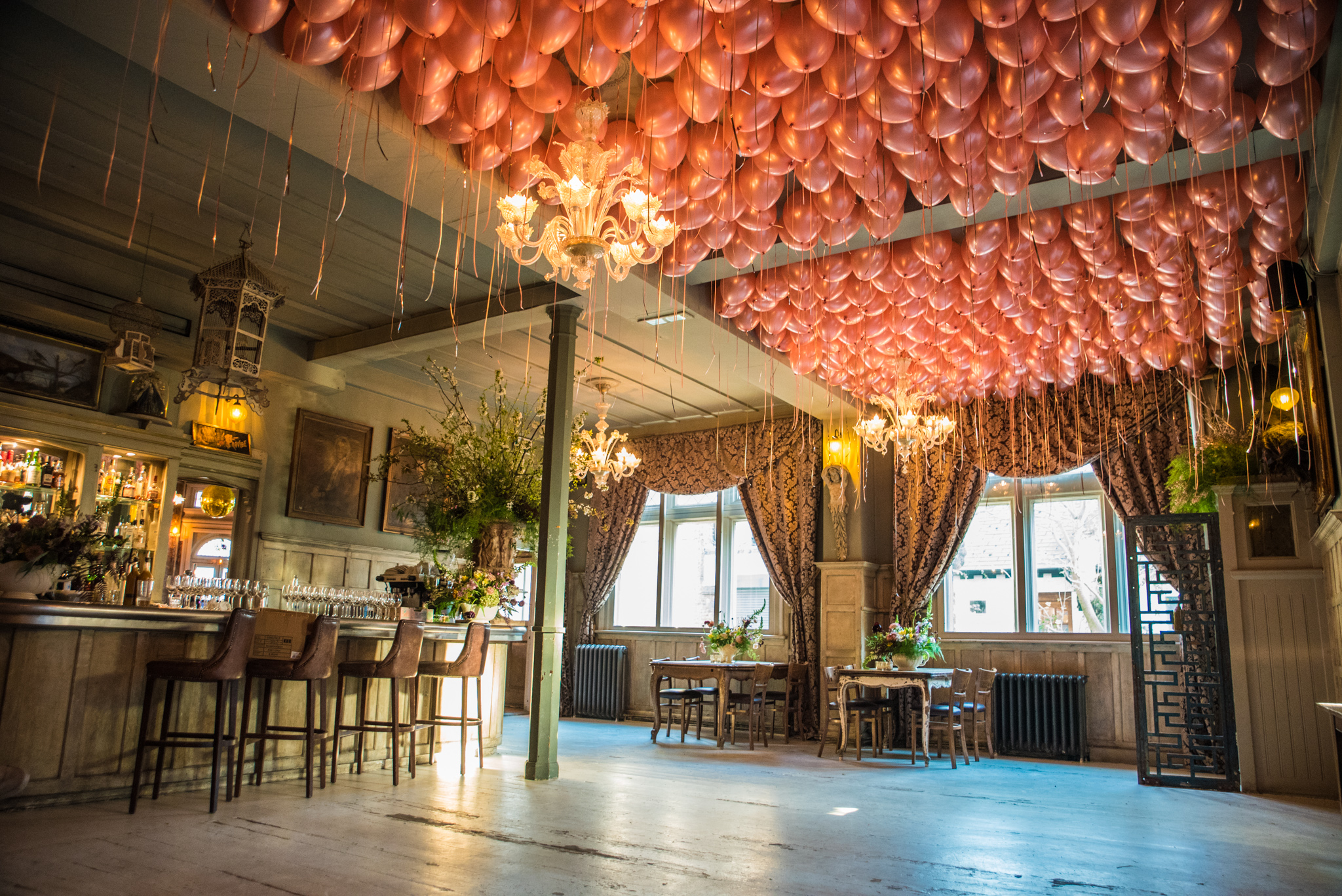 Elegant dining room with pink balloon ceiling, perfect for celebrations and gatherings.