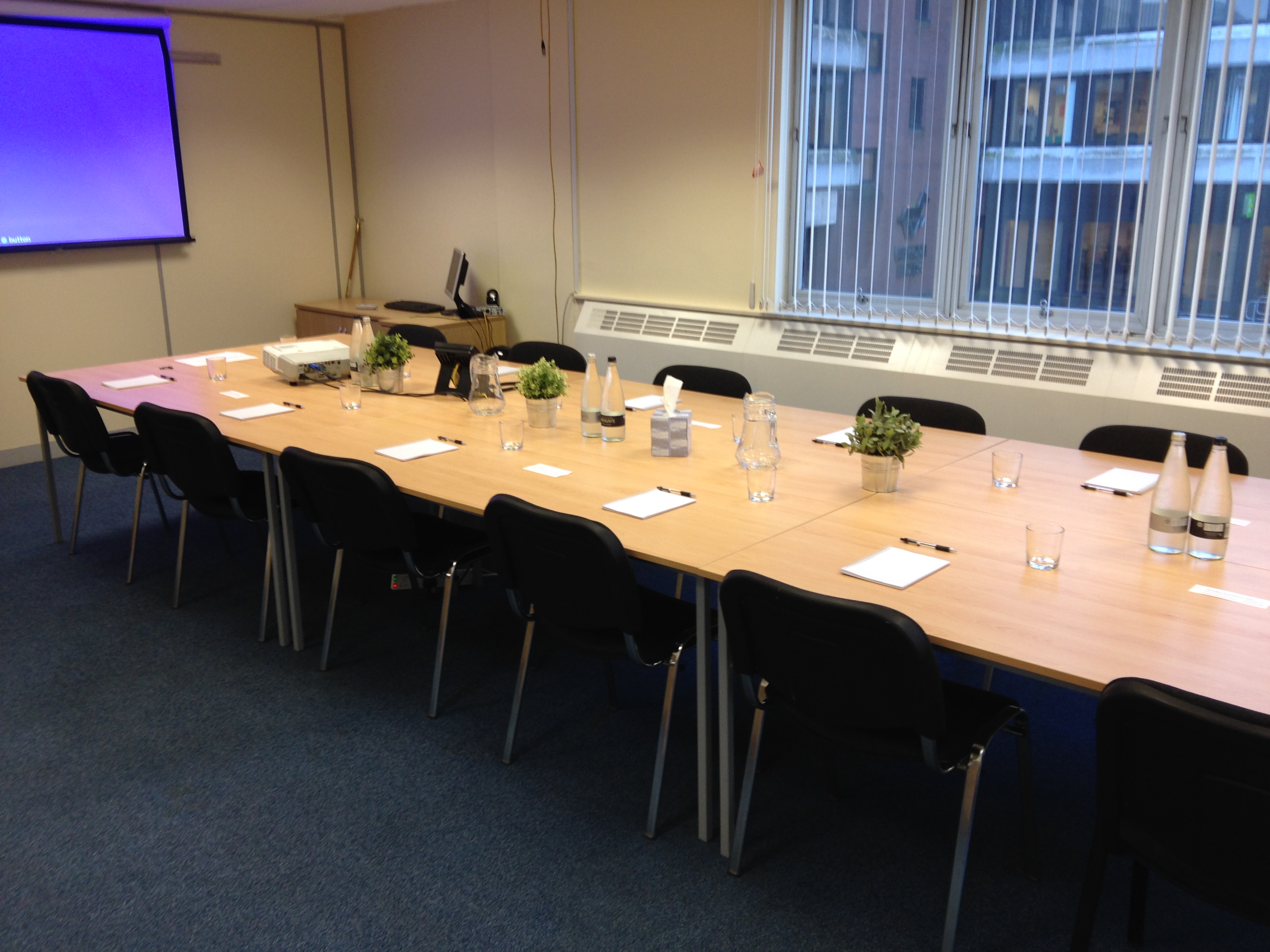 Meeting room with long table, ready for professional meetings and workshops.