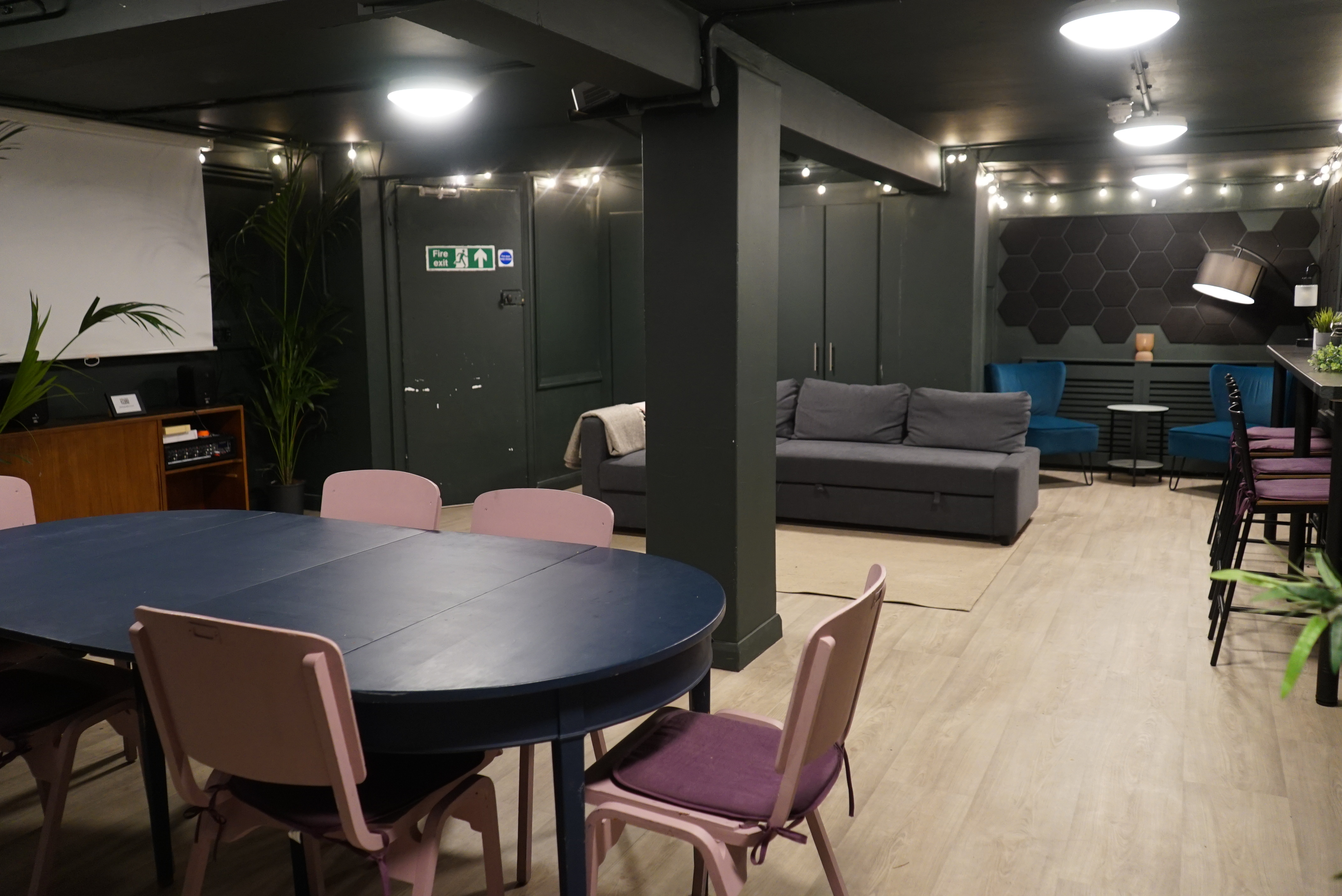 Versatile basement event space with round table, ideal for meetings and workshops.
