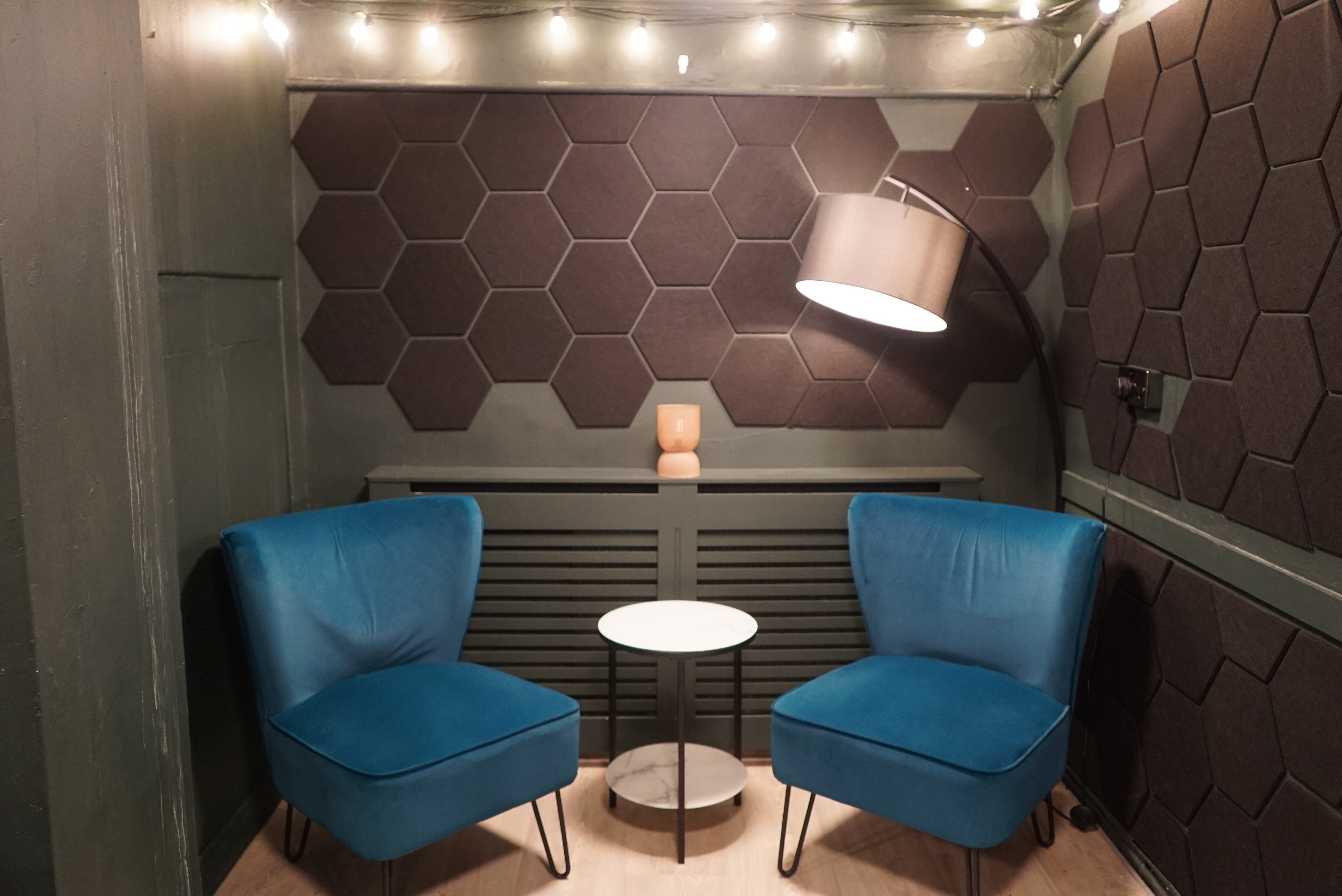 Cozy meeting nook with hexagonal panels at Young Actors Theatre Islington for brainstorming sessions.