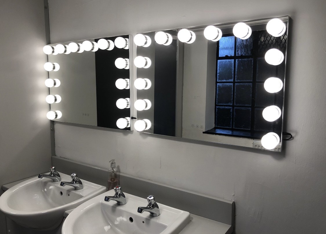 Well-lit restroom with two sinks and mirrors at Young Actors Theatre Islington event space.