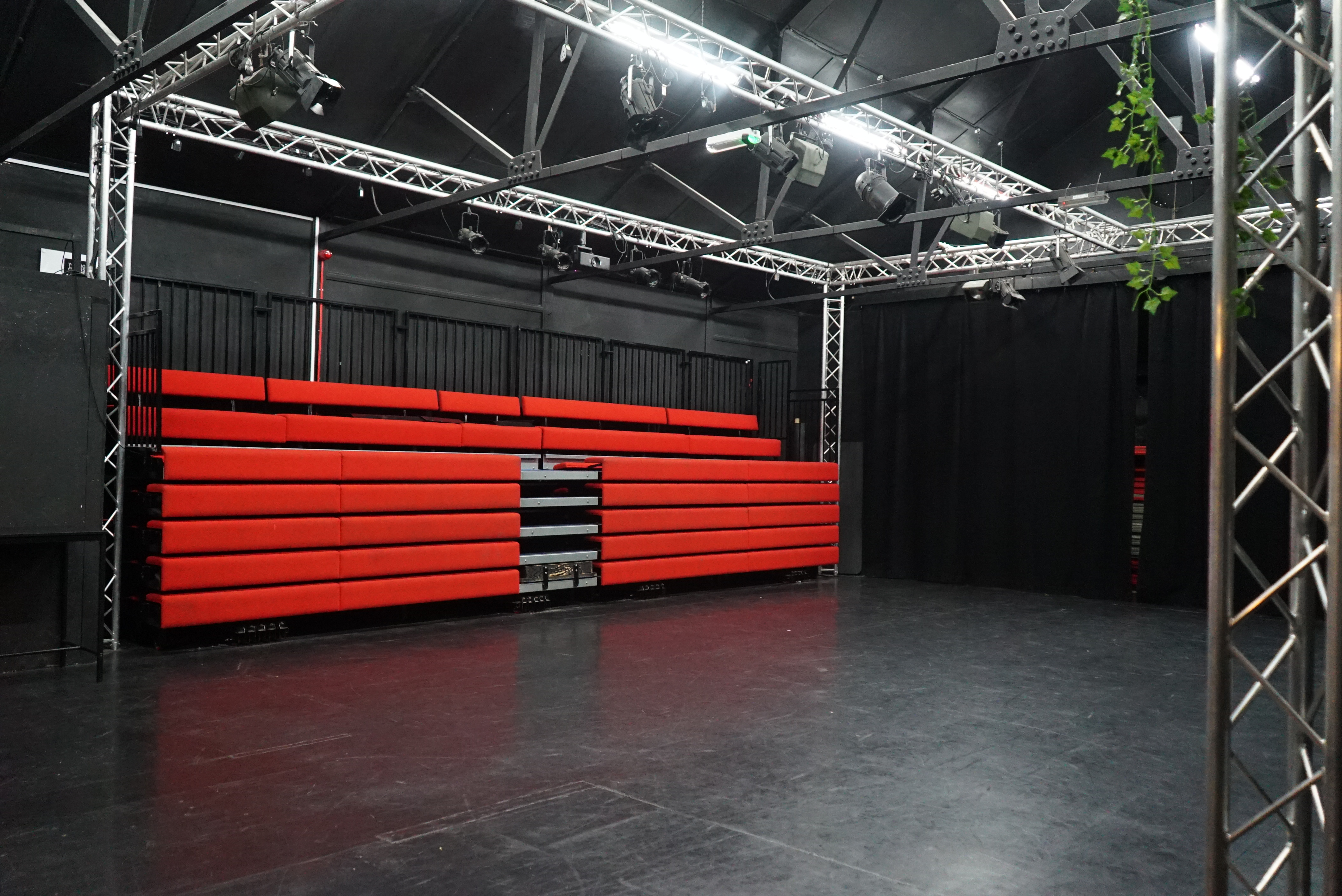 Theatre Space at Young Actors Theatre Islington with tiered red seating for events.
