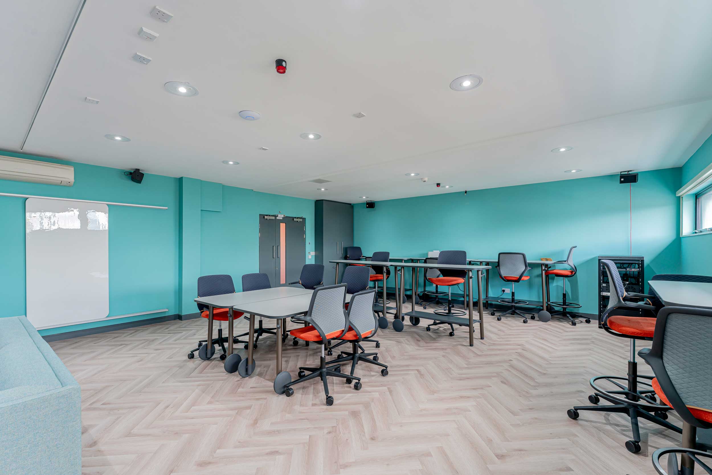 Modern meeting room in FACT Liverpool with turquoise walls for workshops and presentations.