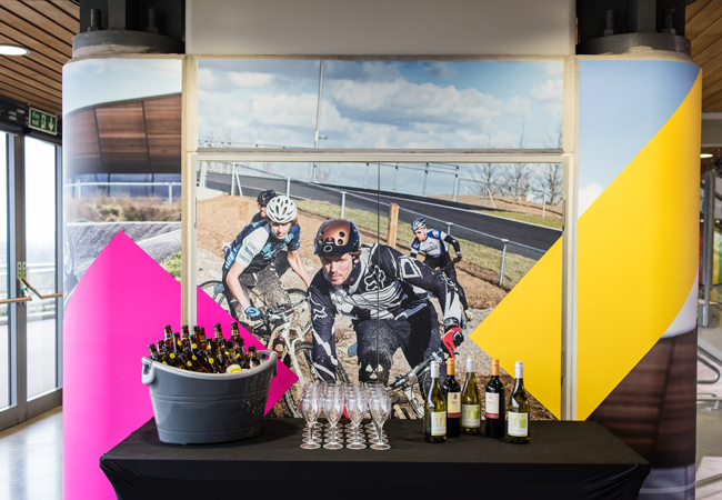 "Vibrant Lee Valley VeloPark event space with cyclists, ideal for corporate gatherings and networking."