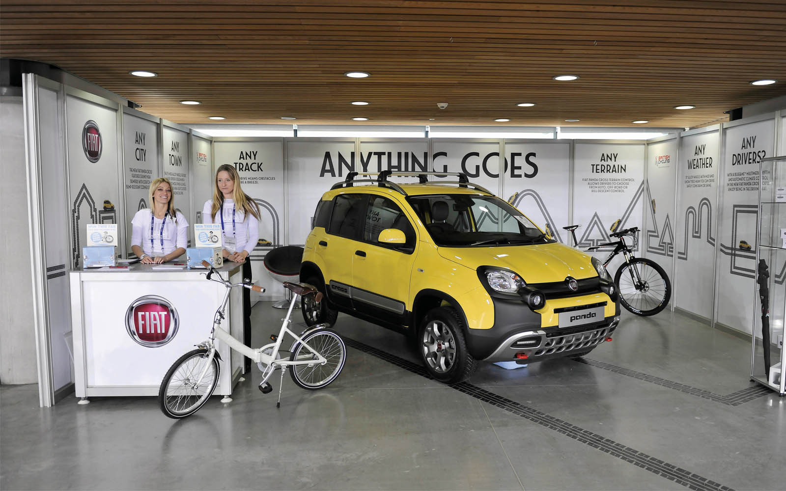 Vibrant trade show booth with yellow Fiat car and bicycles at Lee Valley VeloPark.