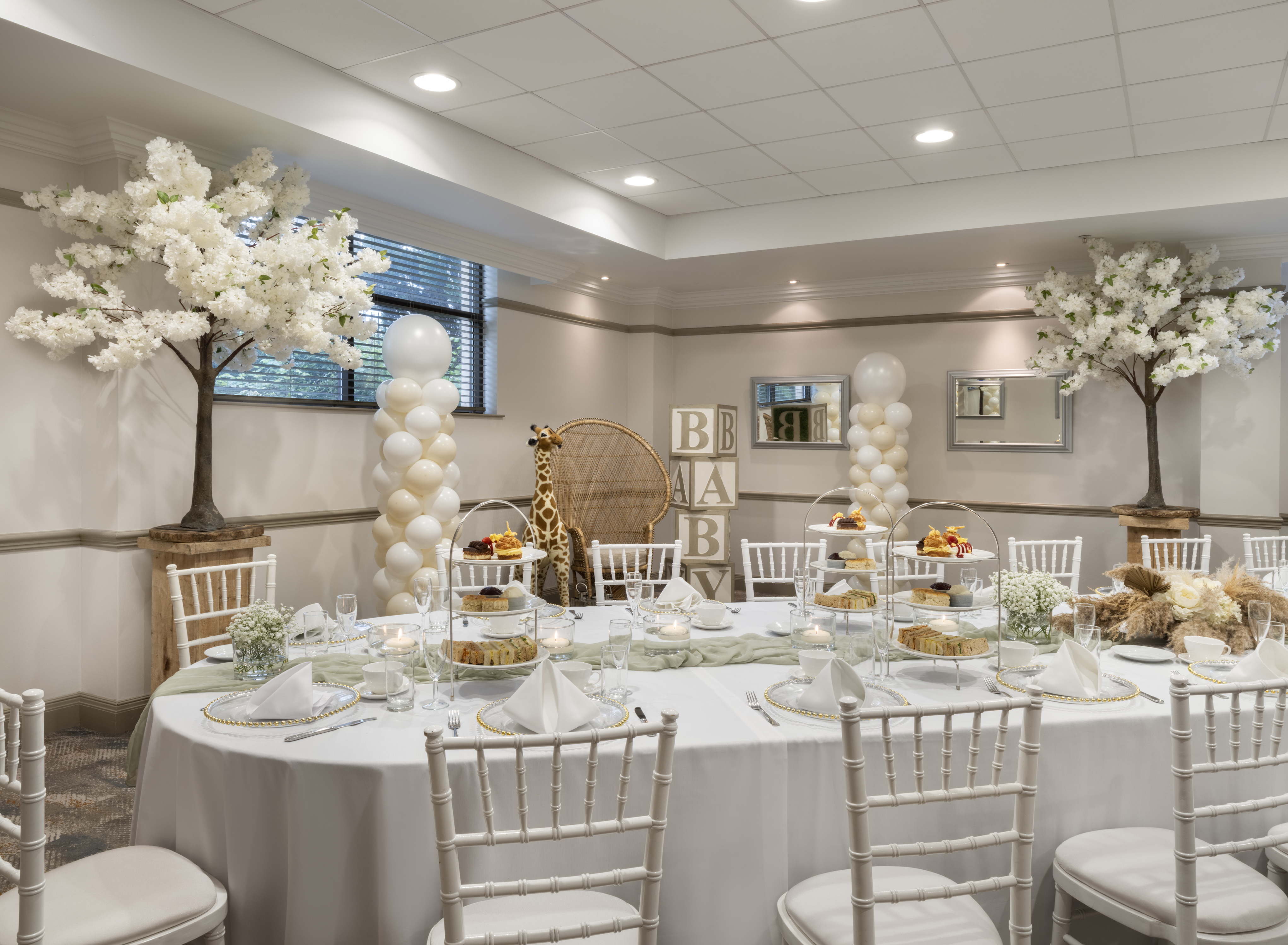 Hornby Room at Delta Hotels: elegant baby shower venue with floral decor and giraffe backdrop.