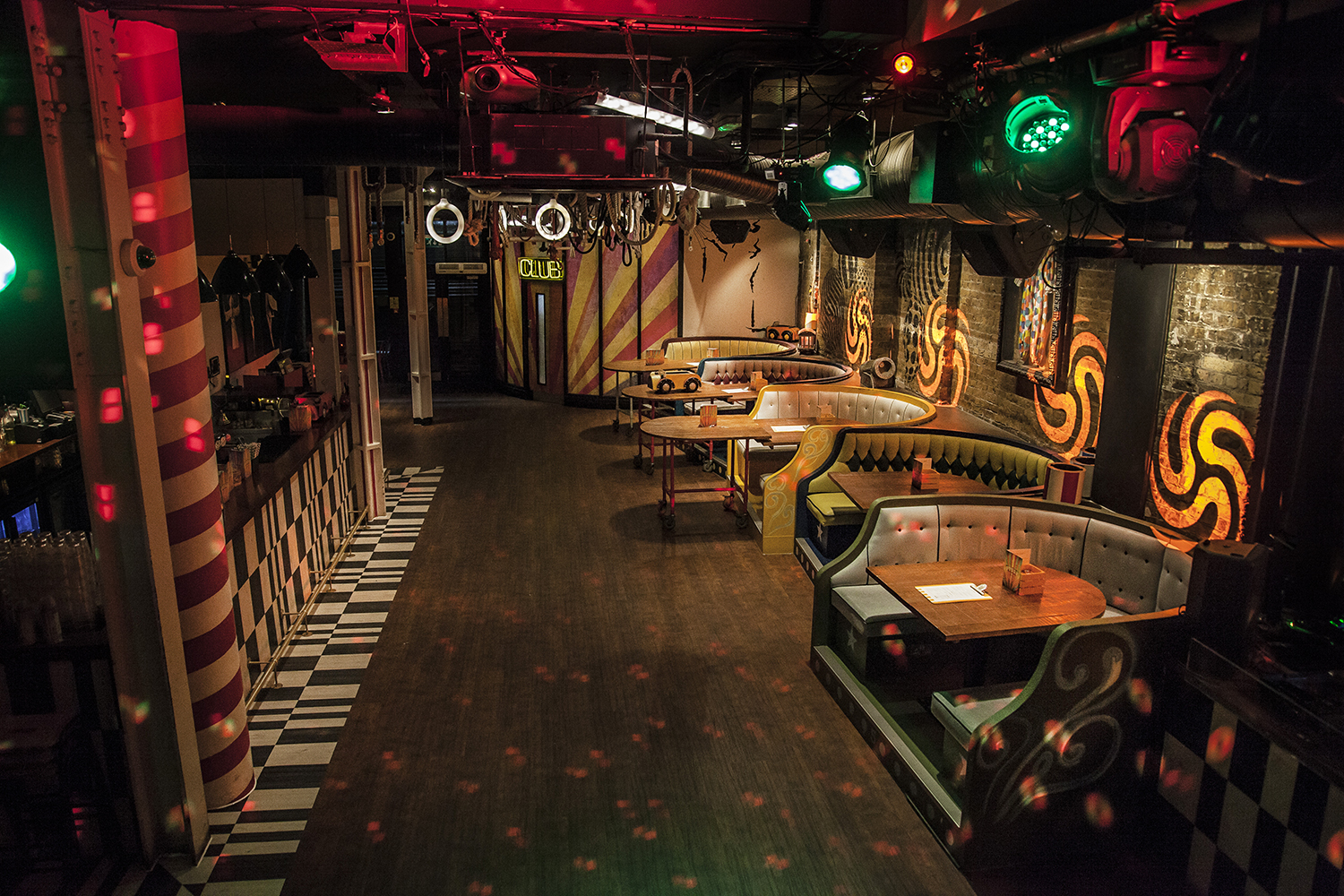 Vibrant Trapeze Bar main event space with colorful lighting for networking and parties.