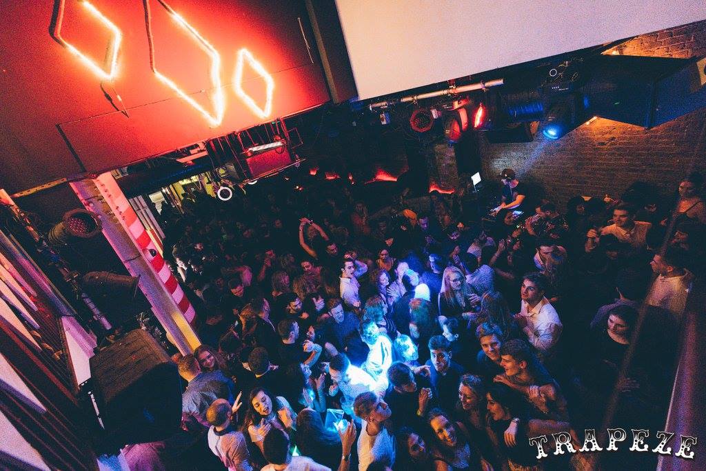 Vibrant crowd at The Mezzanine, Trapeze Bar for a lively networking event.