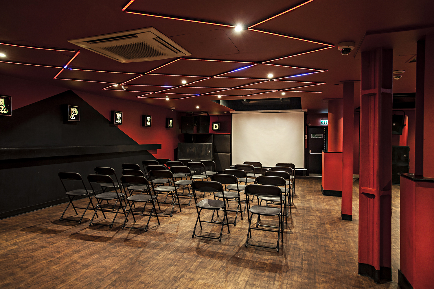 The Basement Club at Trapeze Bar: modern meeting space with black chairs for workshops.