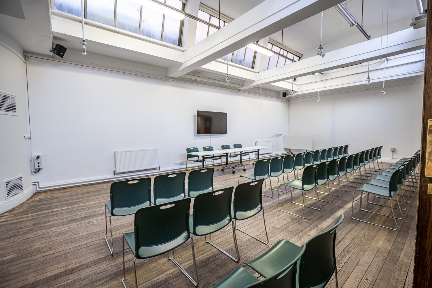 Brockway Room in Conway Hall: versatile meeting space with green chairs, ideal for workshops.