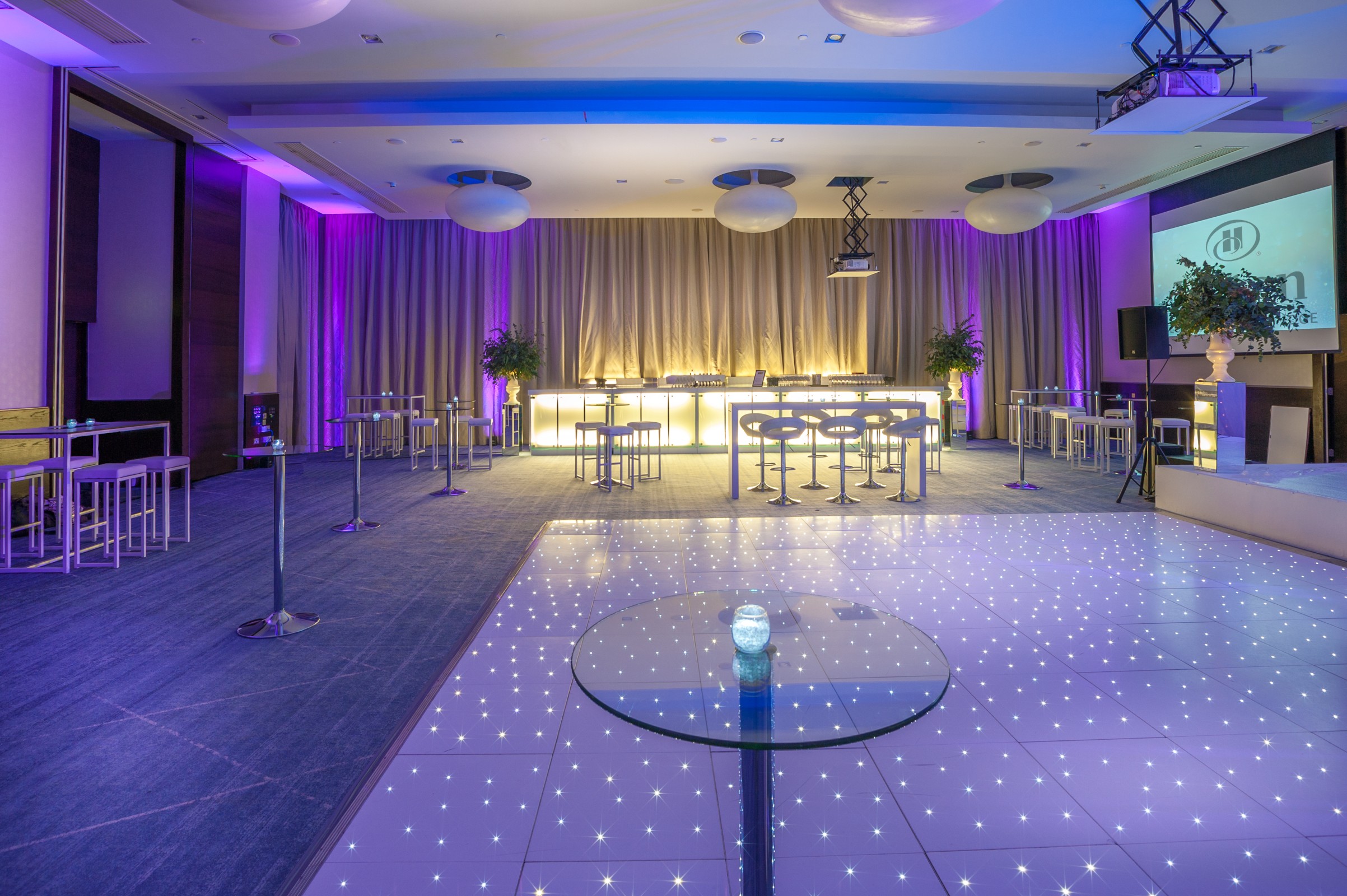 Tower Suite at Hilton London Tower Bridge, modern event space with illuminated dance floor.