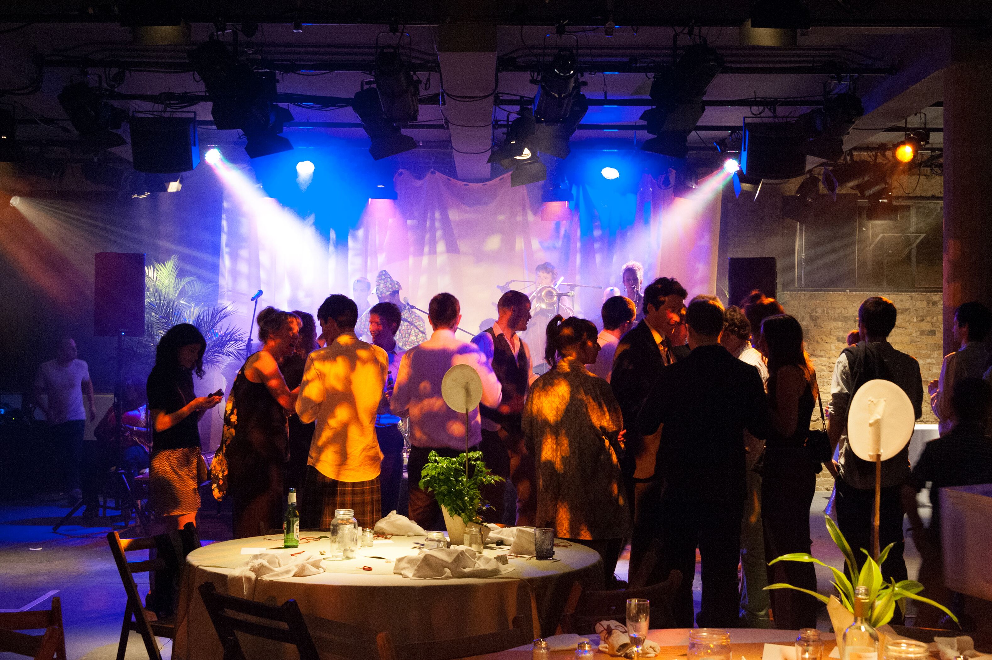 Bush Theatre auditorium with guests mingling under dynamic lighting at a lively event.