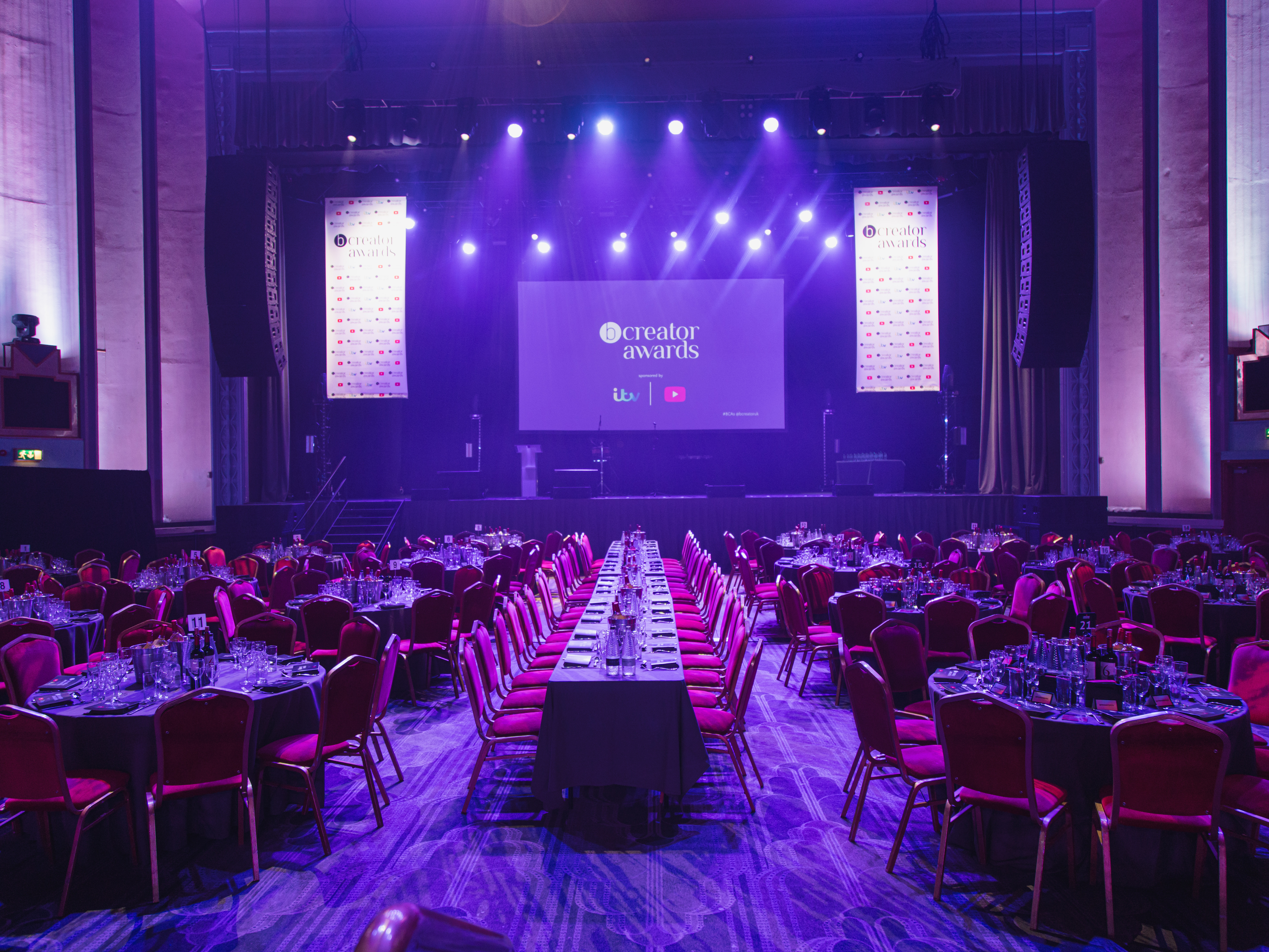 Elegant Grand Hall in Troxy set for an awards ceremony with red chairs and ambient lighting.