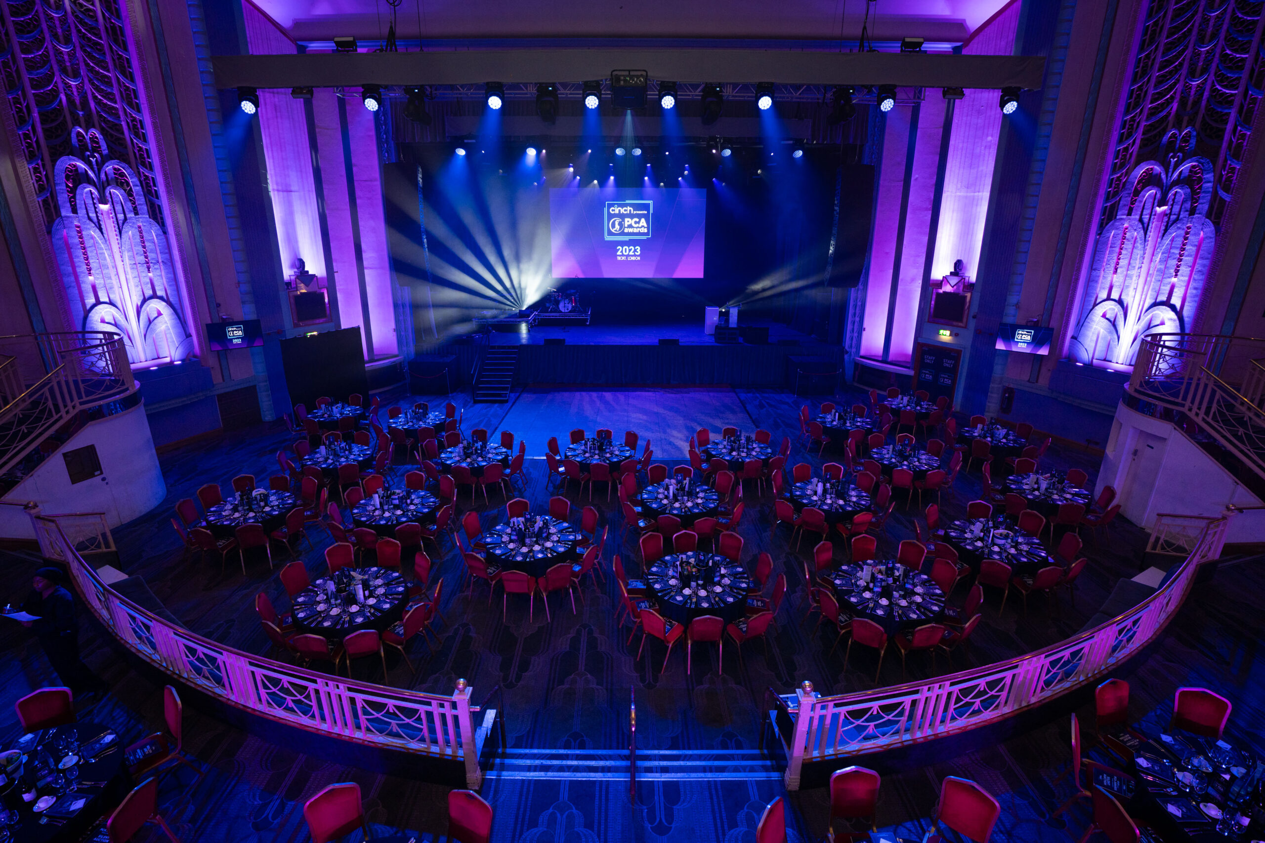 Elegant Grand Hall at Troxy, set for a gala with purple lighting and round tables.