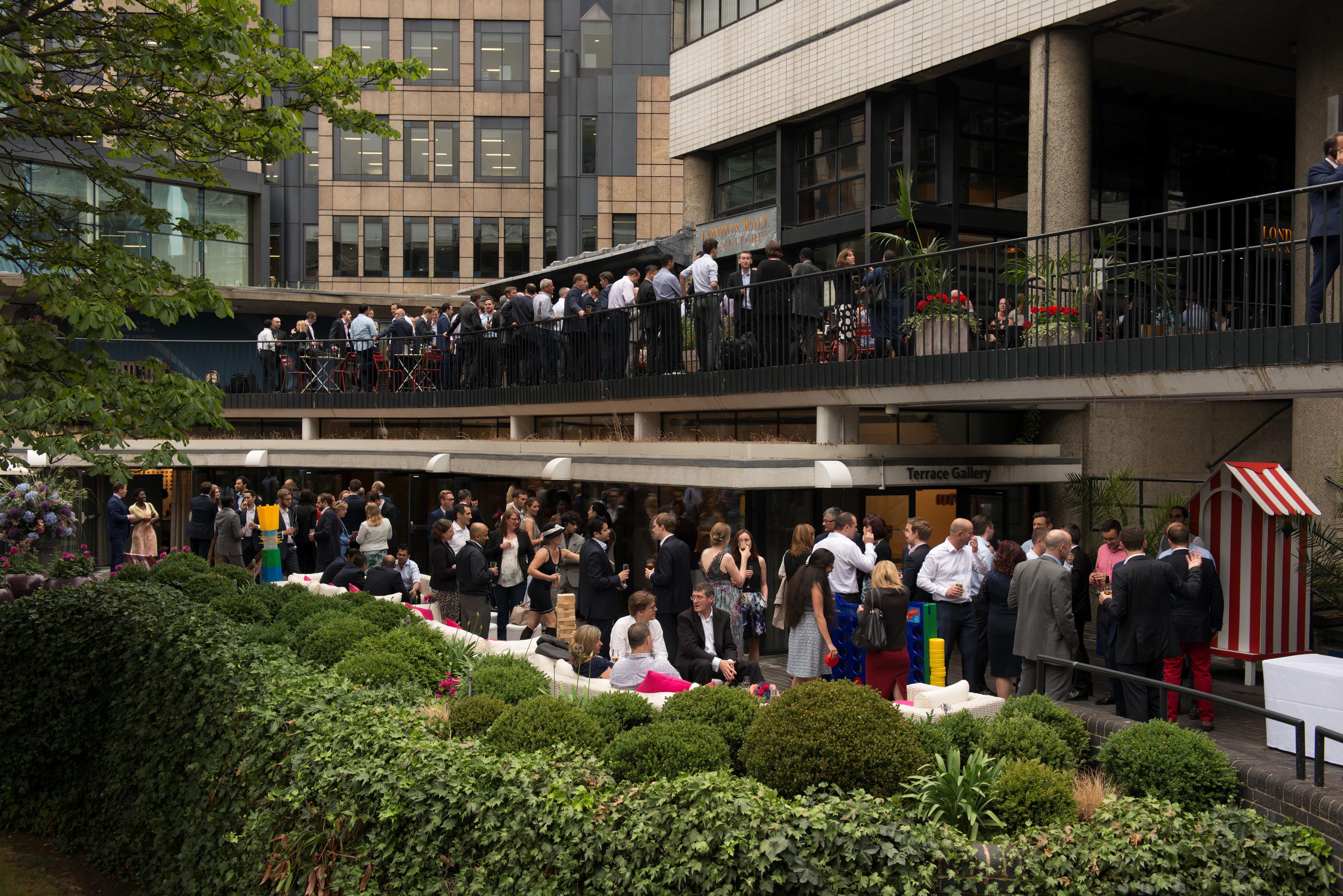 Outdoor networking event at London Museum Spaces with lush greenery and seating.