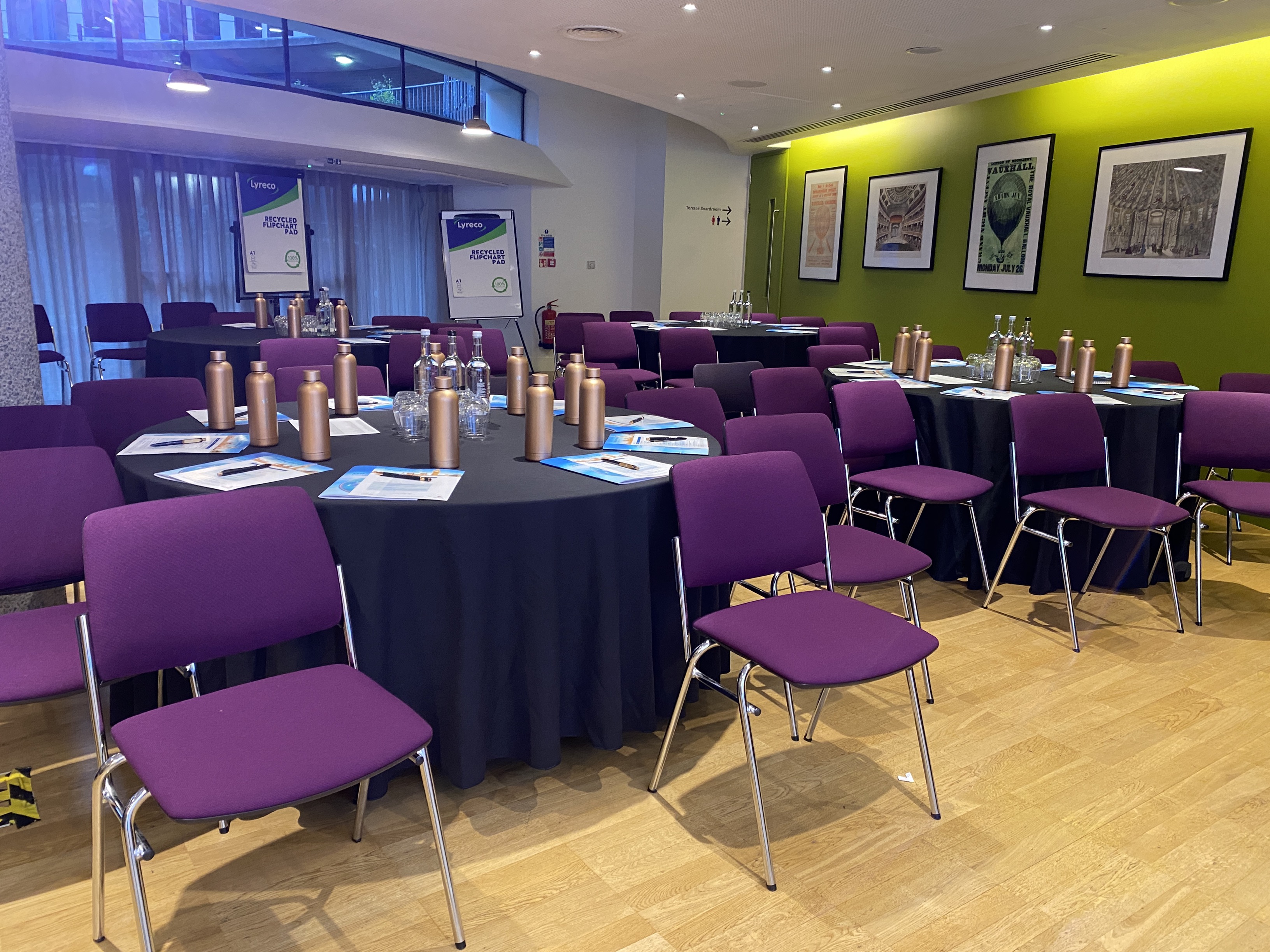 Terrace Gallery meeting space with round tables and purple chairs, perfect for workshops.