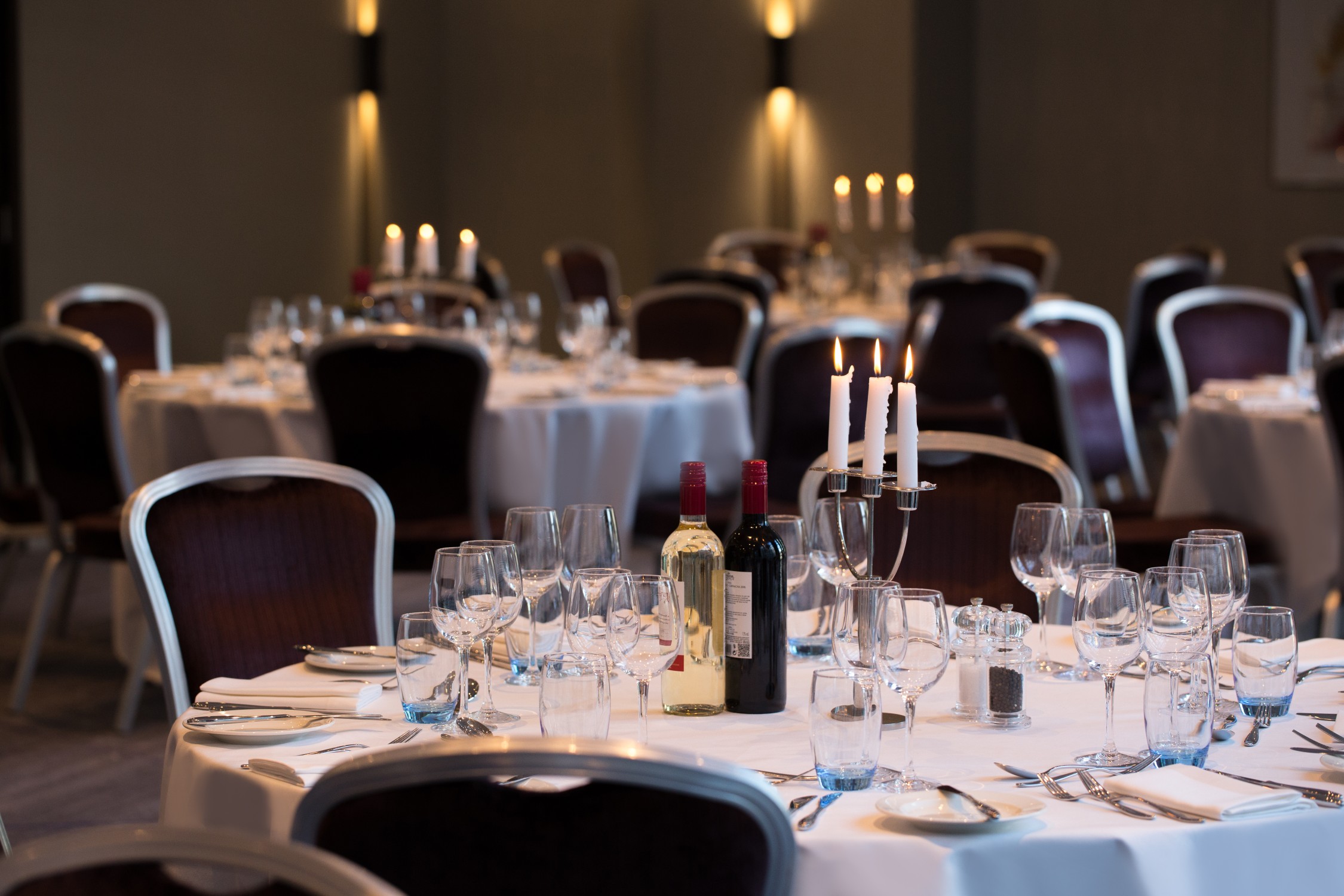 Elegant dining room at Hilton London Tower Bridge for formal events, featuring round tables.