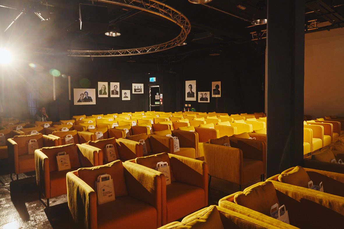 Event space with yellow seating, ideal for networking and panel discussions.