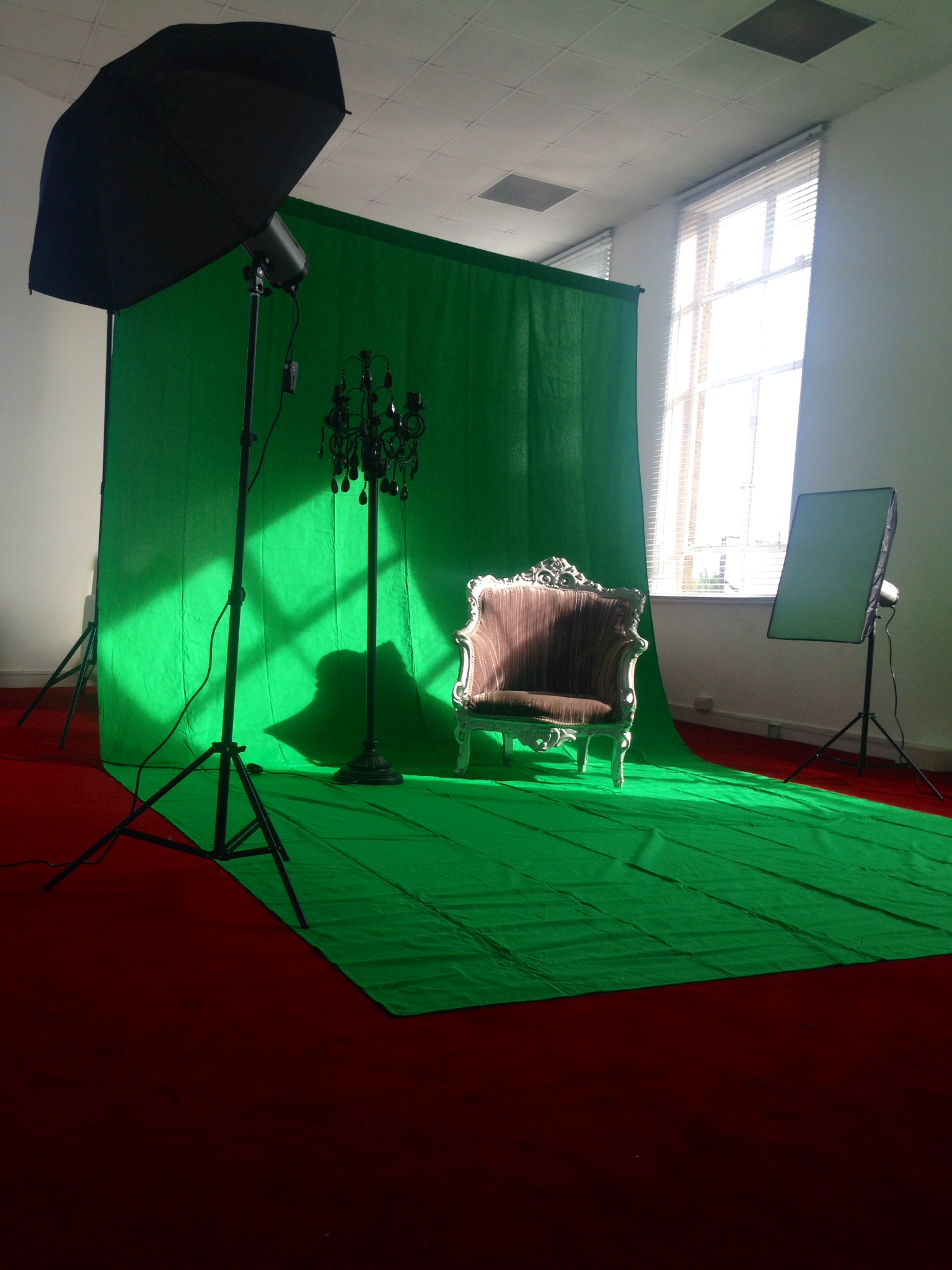 Photo booth setup with green backdrop and elegant chair for engaging events.
