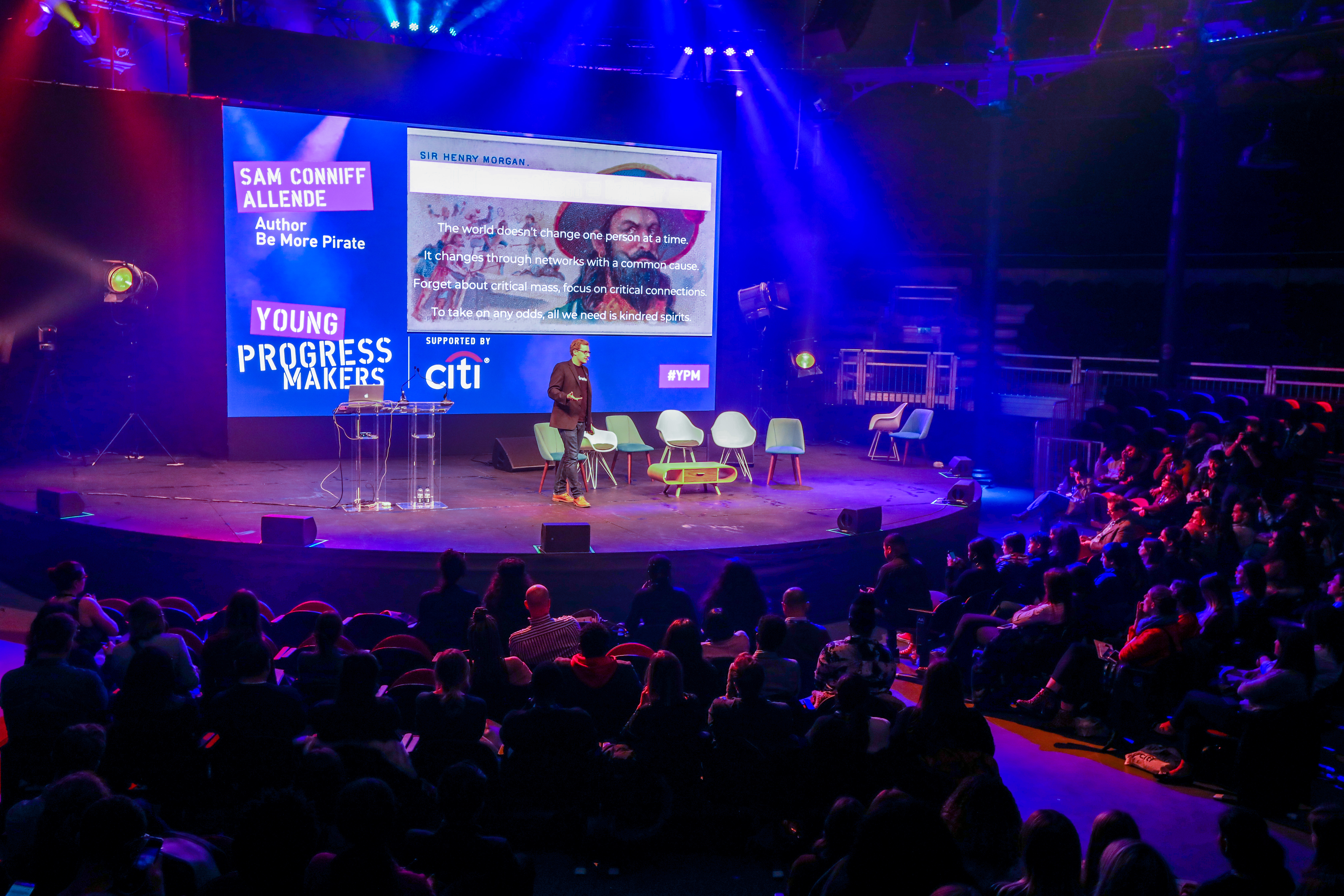 "Main Space Roundhouse event setup with speaker engaging audience in a professional venue."