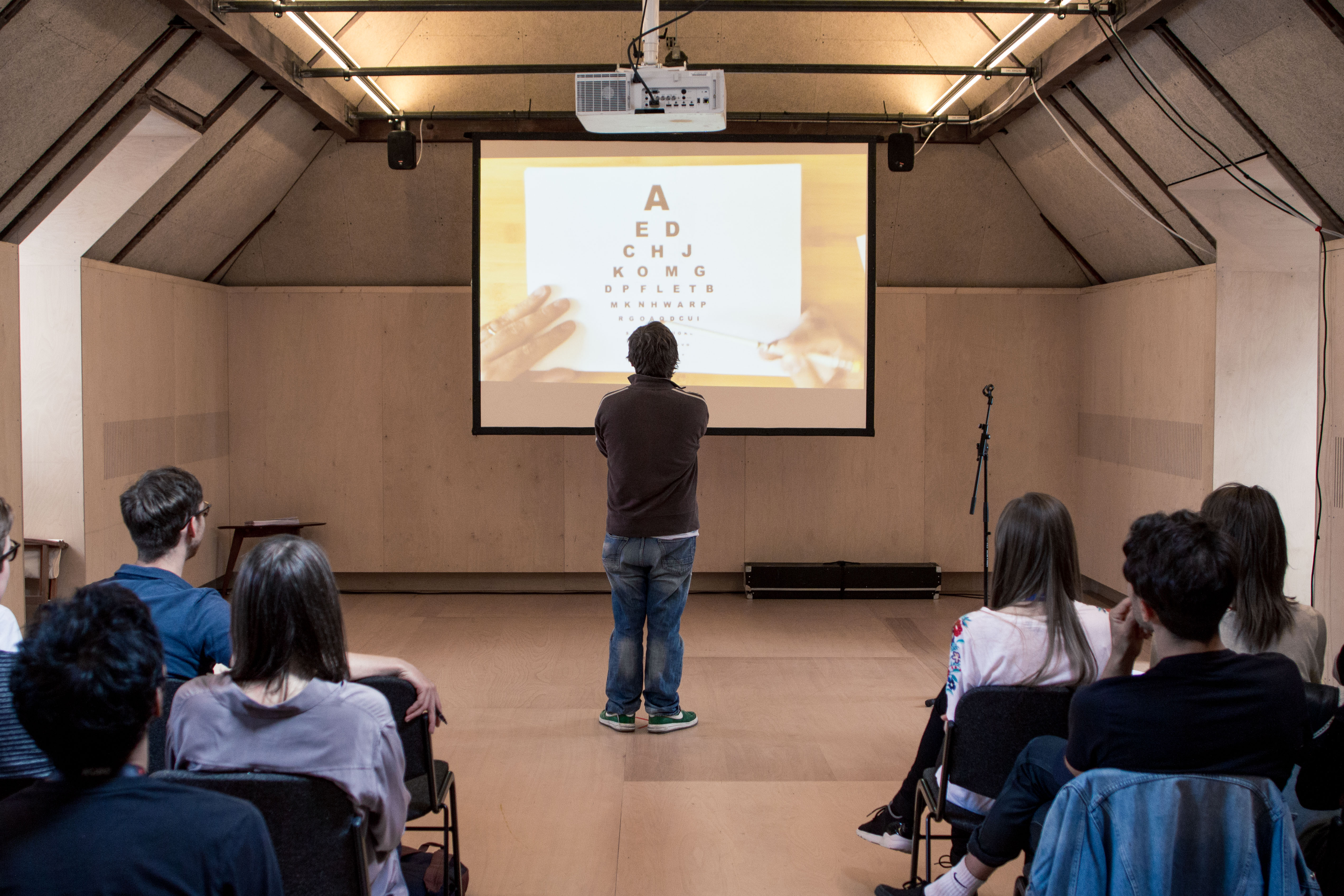 Intimate workshop at Bush Theatre with engaged audience and visual aid presentation.