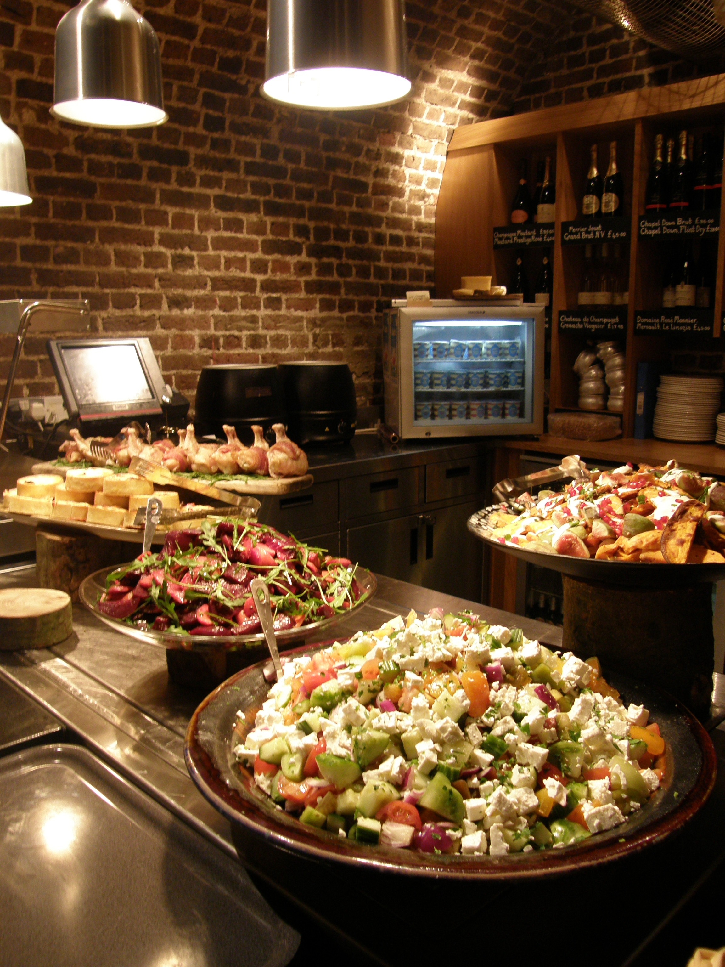 Buffet setup with vibrant salads in The Crypt, perfect for events and networking.