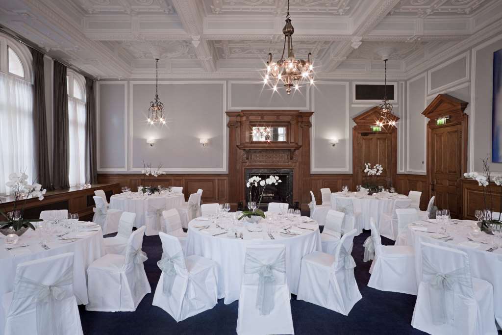 Elegant event space at Andaz London with round tables and chandeliers for formal gatherings.