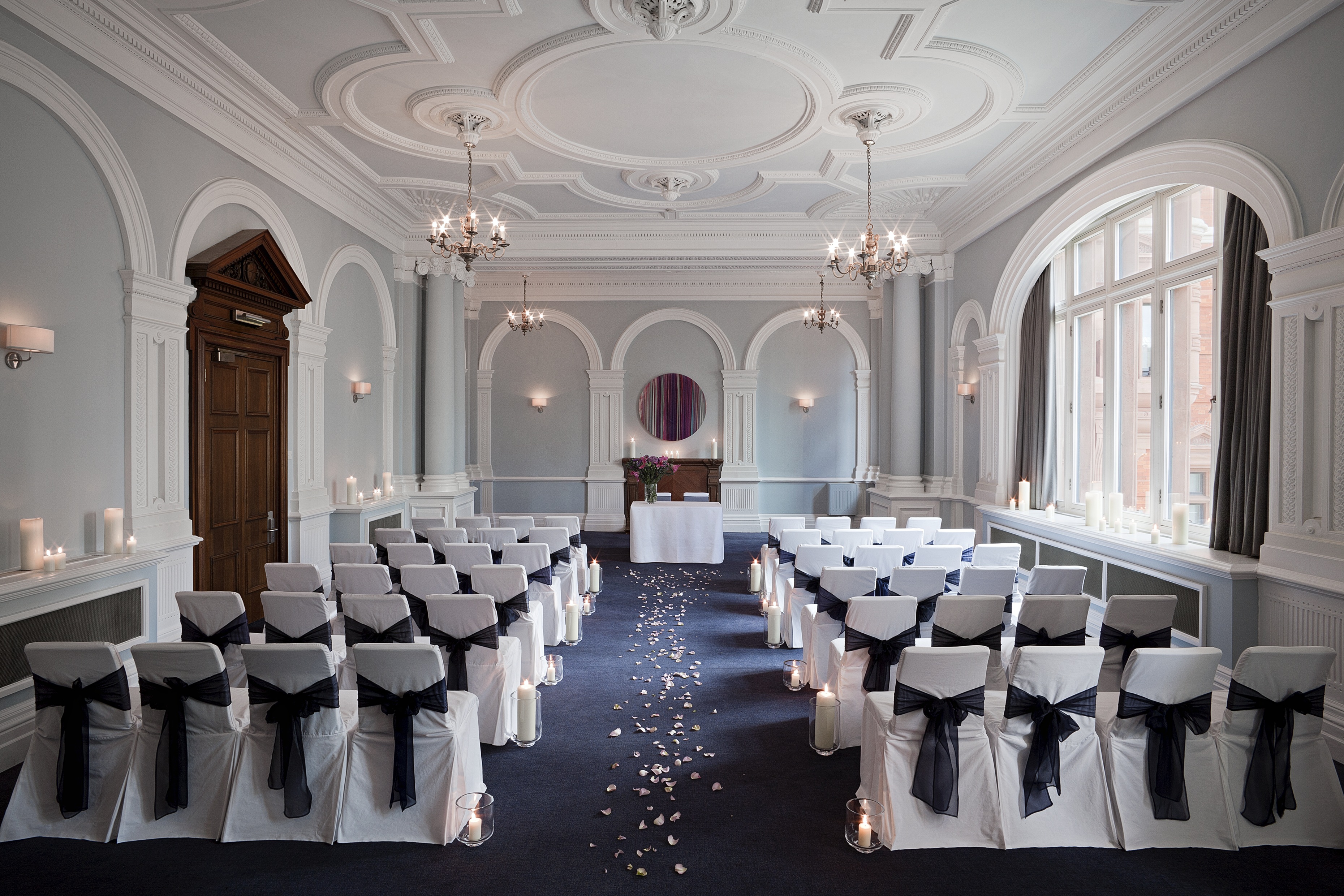 Fenchurch Suite at Andaz London: elegant wedding venue with white chairs and rose petals.