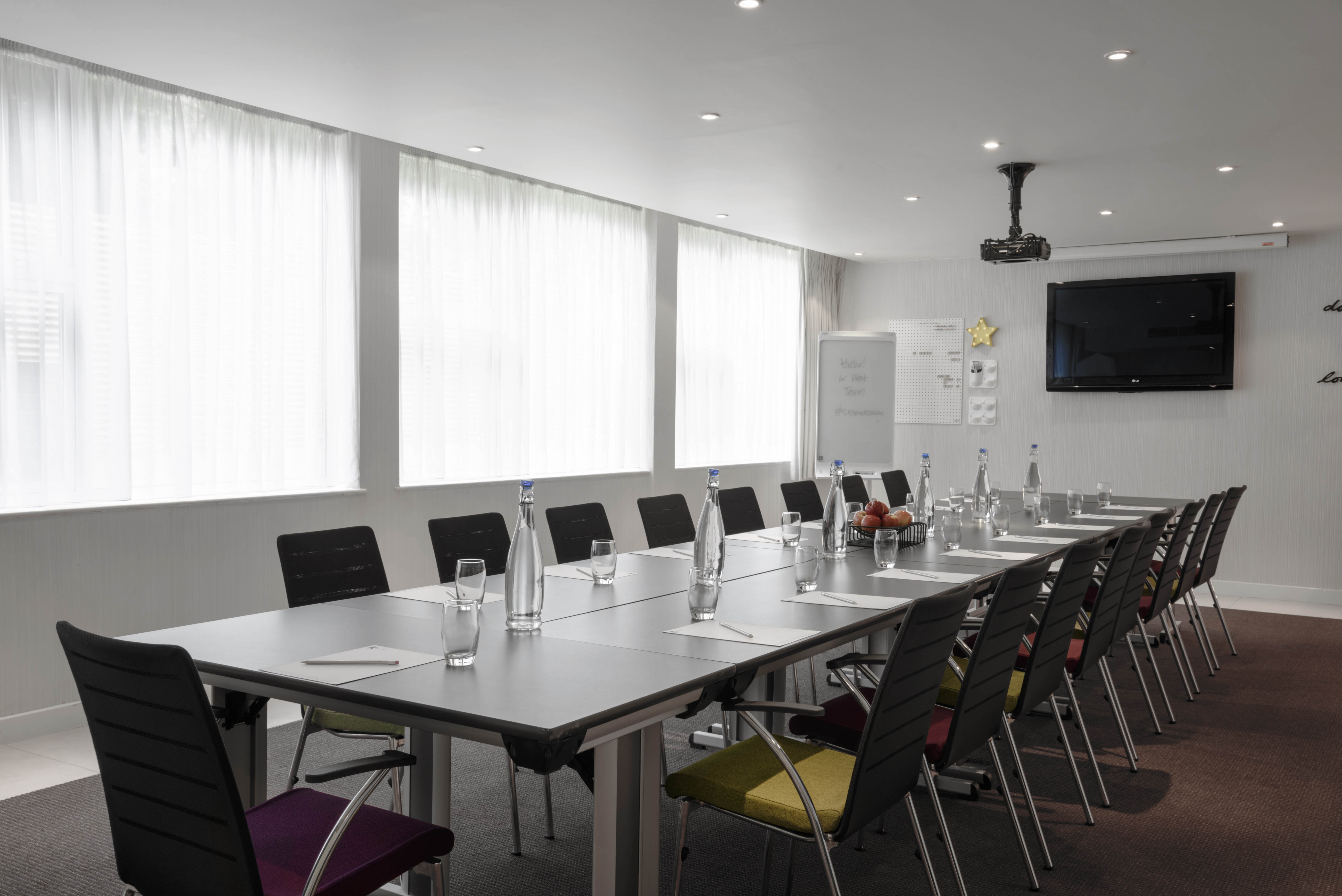 Modern meeting room at K West Hotel with sleek table, ideal for workshops and presentations.