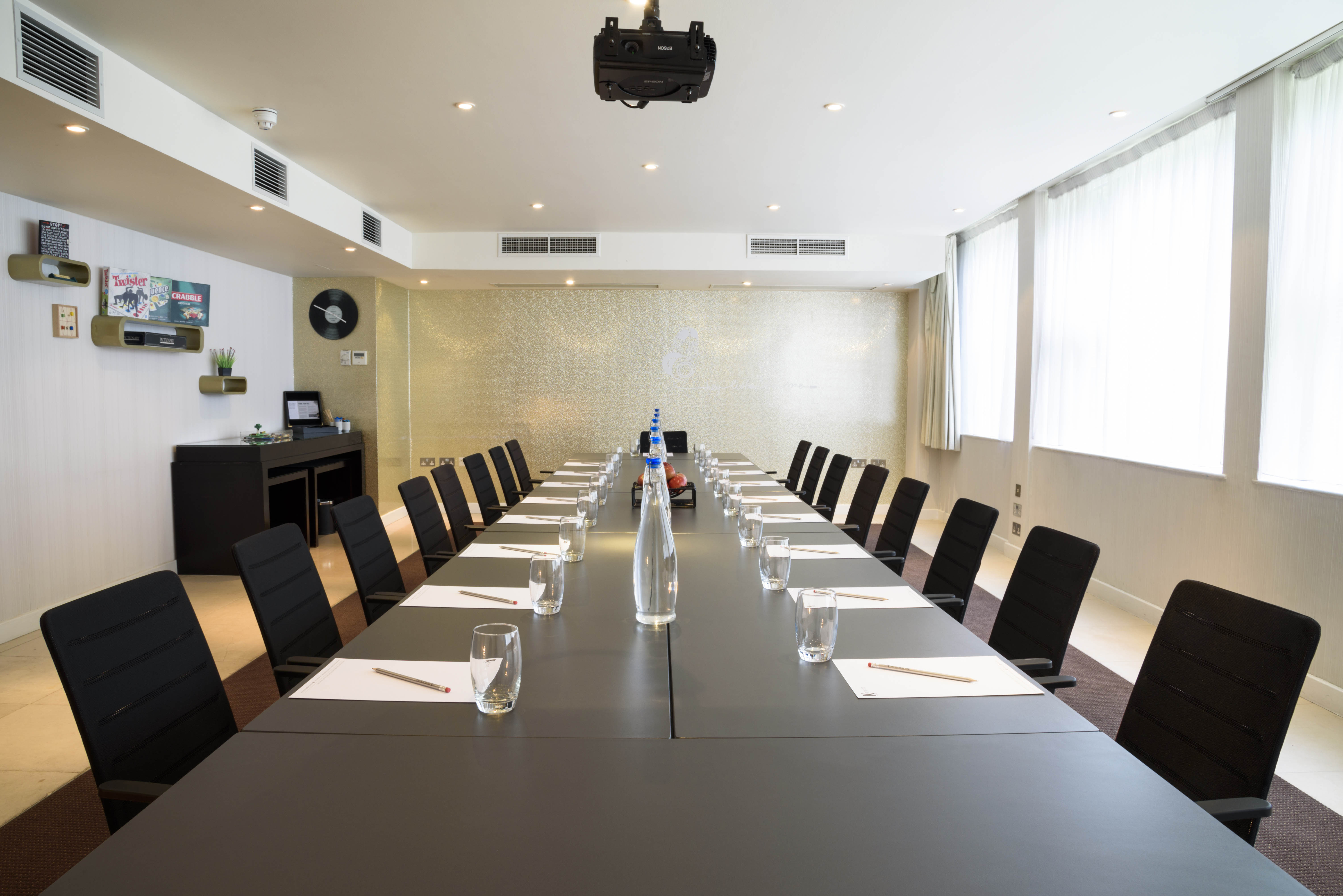 Modern meeting room at K West Hotel, featuring a long table for corporate events.