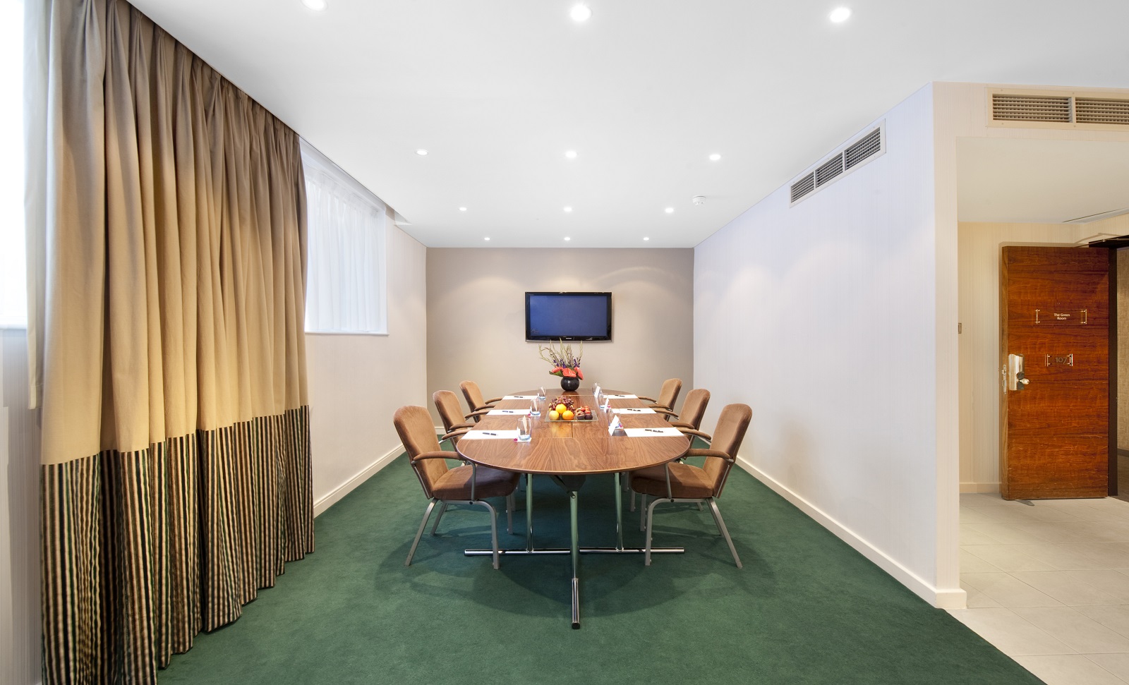 Green Room at K West Hotel: modern meeting space with round table for professional events.