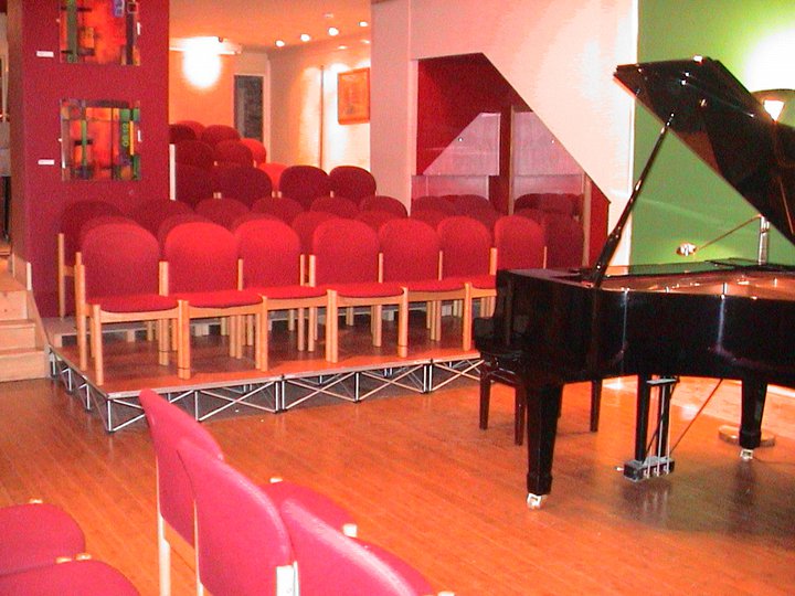Cozy Salon Theatre with grand piano, perfect for music recitals and workshops.