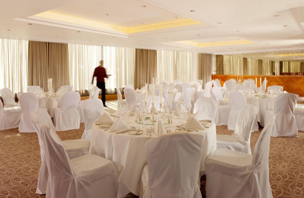 Elegant event space with round tables, ideal for corporate gatherings at Royal Garden Hotel.