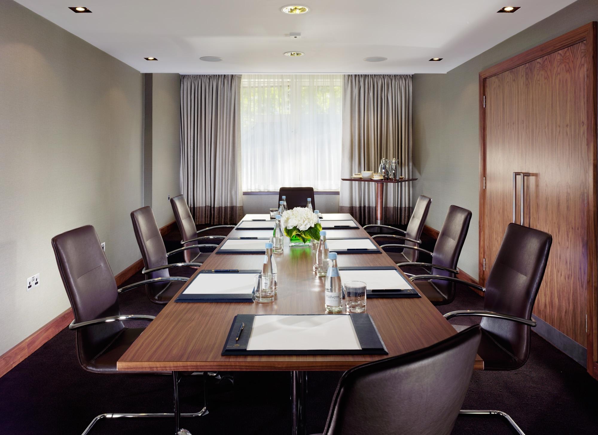 Executive Boardroom at Royal Garden Hotel with sleek wooden table for professional meetings.