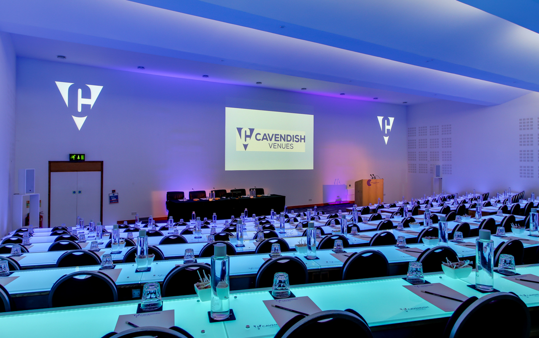 Cavendish Conference Centre auditorium set for a corporate event with tables and branding.