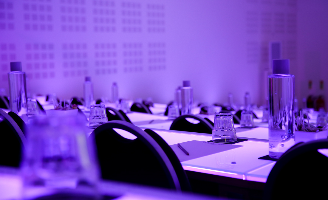 Modern auditorium setup with purple lighting for corporate events and workshops.