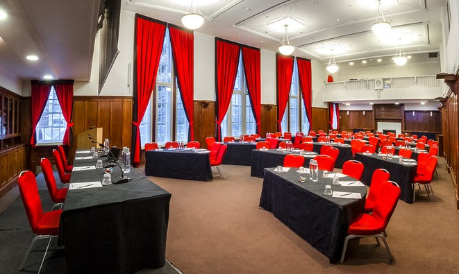 Council Chamber at Hallam Conference Centre with red chairs, ideal for conferences and workshops.