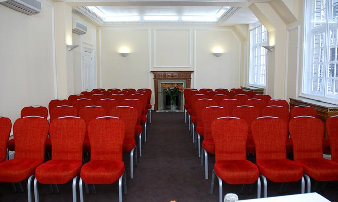 Warren Suite meeting room with red chairs, ideal for presentations and workshops.