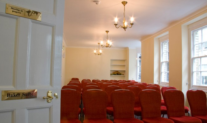 Baker Suite meeting room with red chairs, ideal for workshops and presentations.