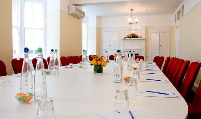 Euston Suite meeting room with white table, red chairs for professional gatherings.