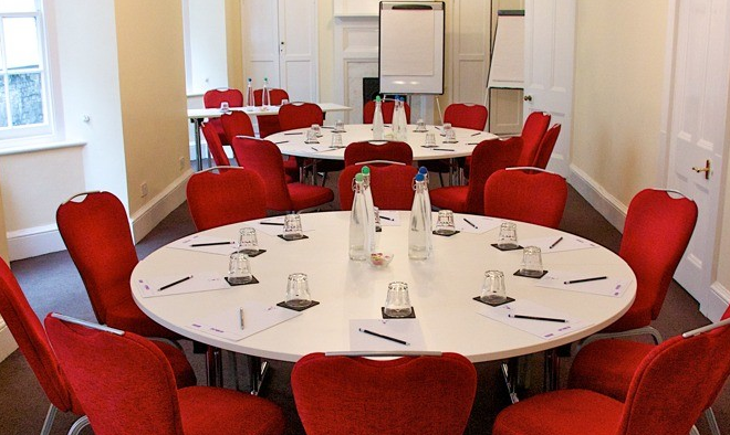 Euston Suite meeting room with round table, red chairs for collaborative events.