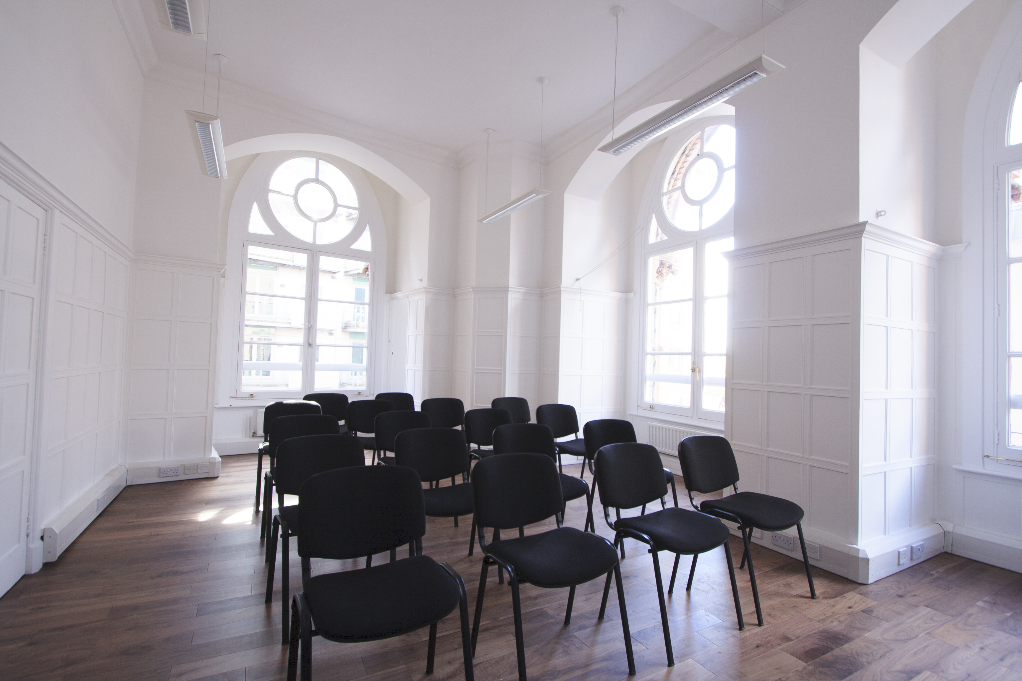 Westminster Room: minimalist meeting space with black chairs, perfect for workshops and presentations.