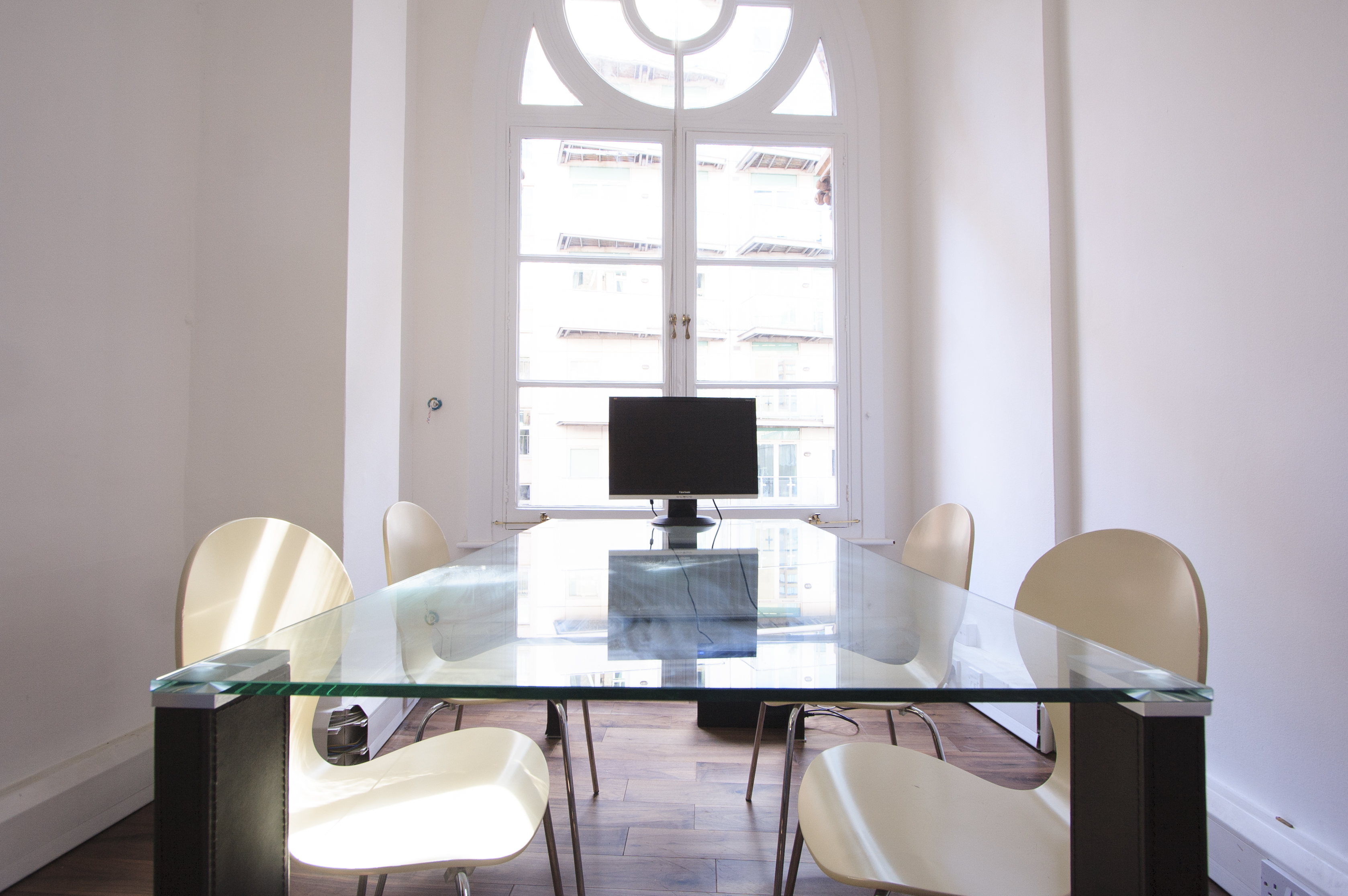 Modern meeting room with glass table, ideal for events and brainstorming sessions.