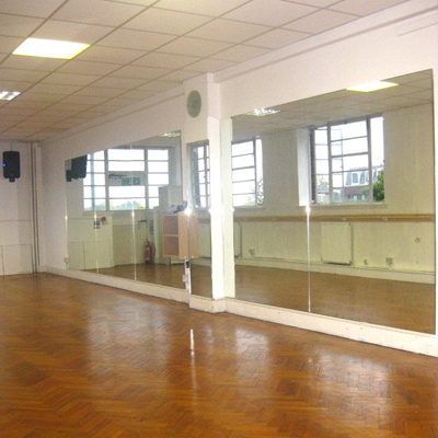 Dance school studio with mirrors and wooden flooring, perfect for workshops and fitness classes.