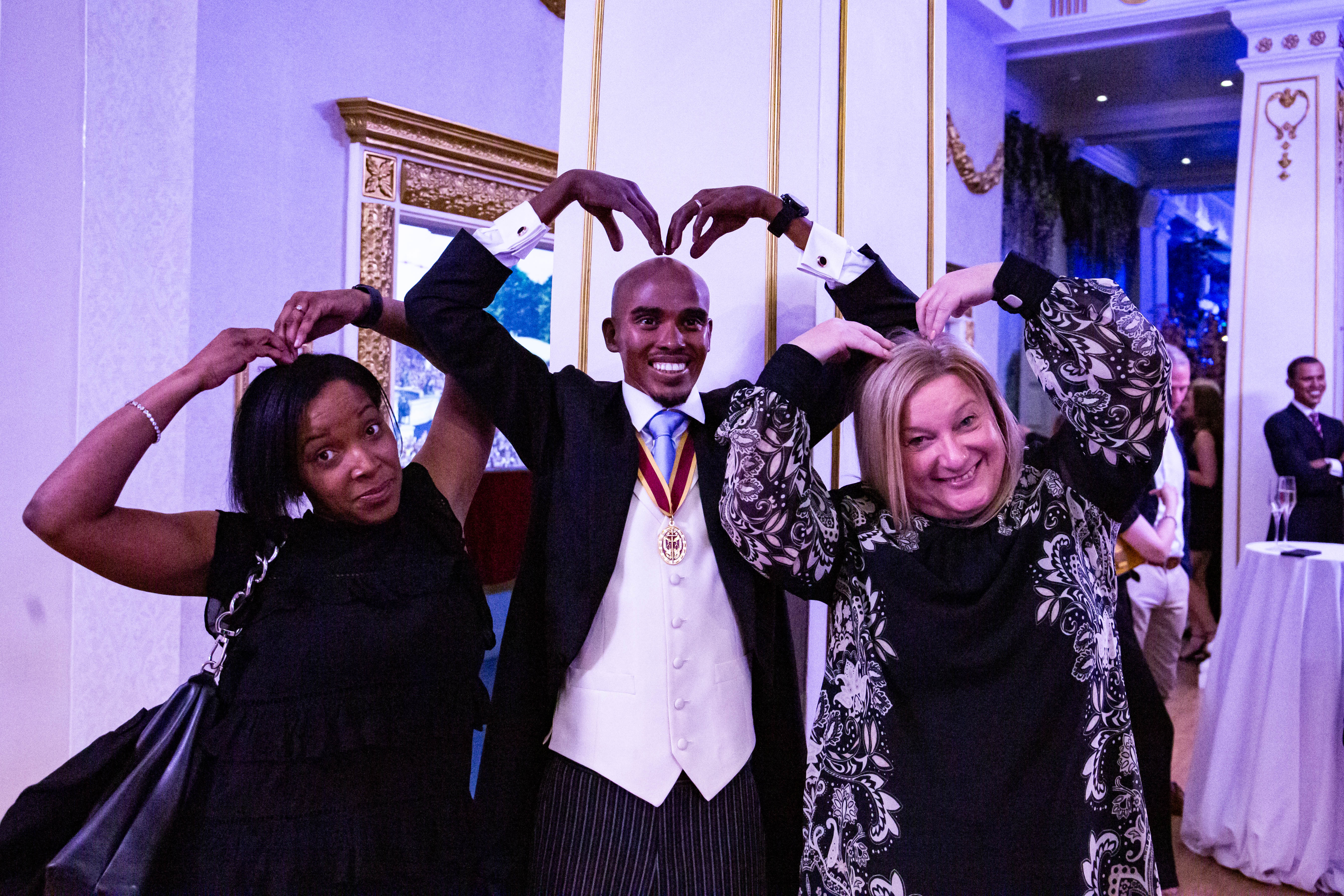 Lively party at Madame Tussauds with guests forming heart shapes, celebrating camaraderie.