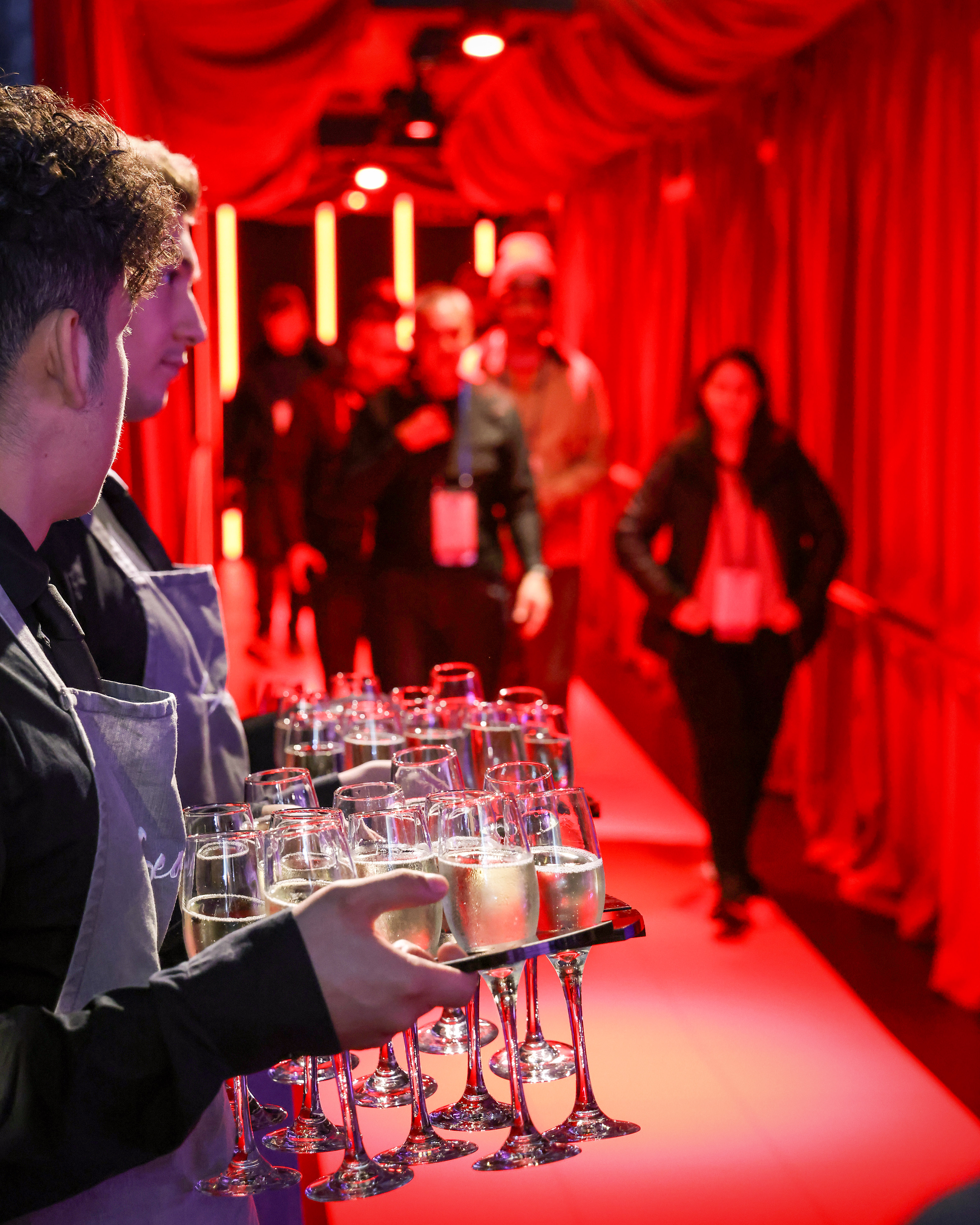 Vibrant party at Madame Tussauds with red lighting and engaging atmosphere for networking.