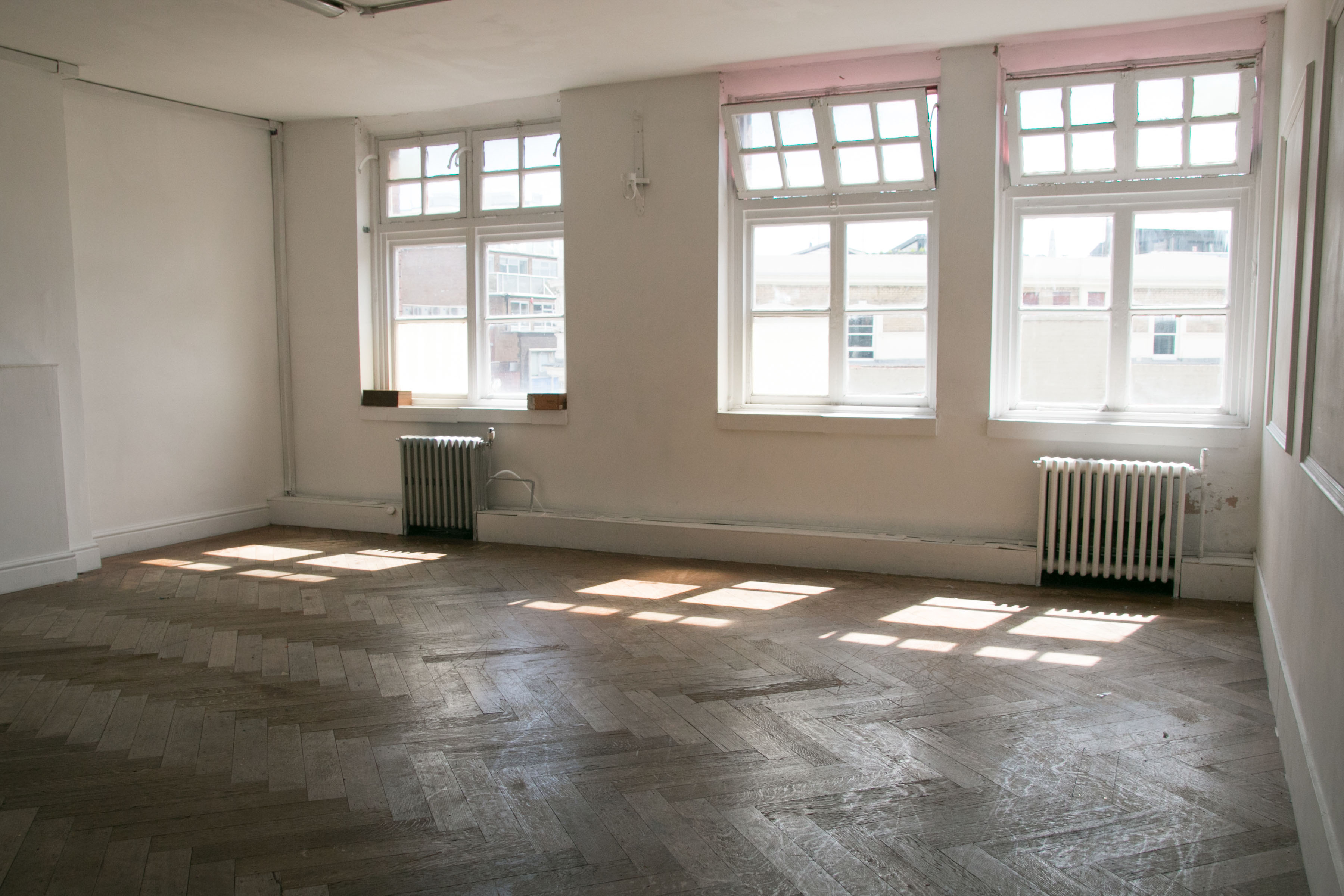 Spacious Factory Studio with large windows, ideal for workshops and events.