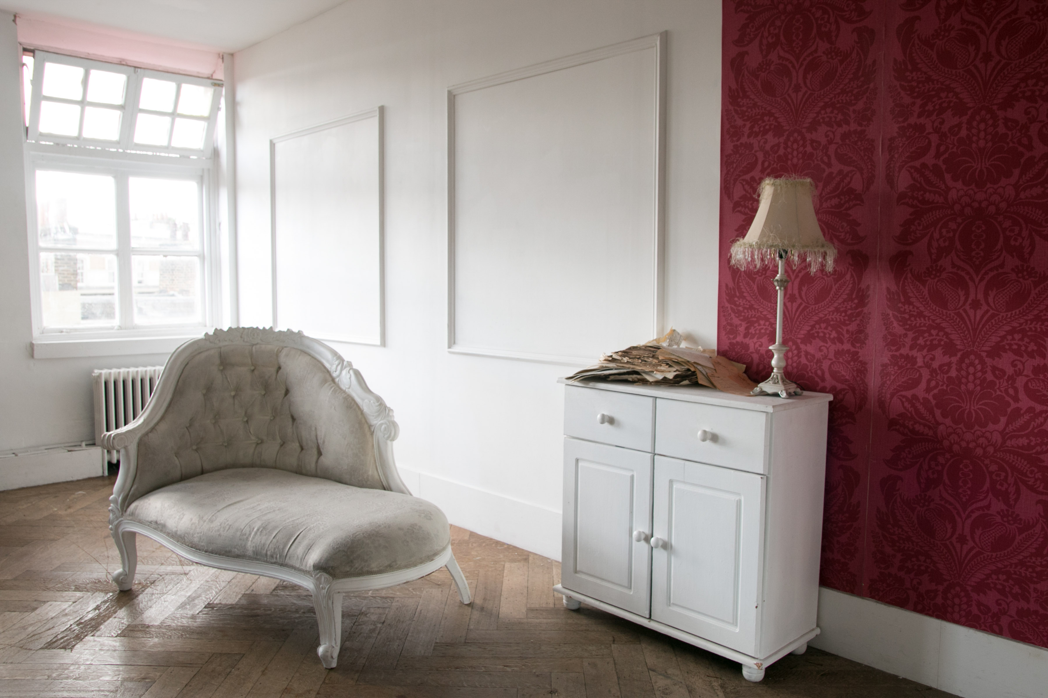 Stylish minimalist meeting space with vintage settee, ideal for creative gatherings.